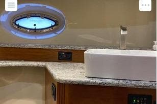 Luxurious bathroom interior of 2008 Cruisers Yachts 560 Express with modern sink and porthole.