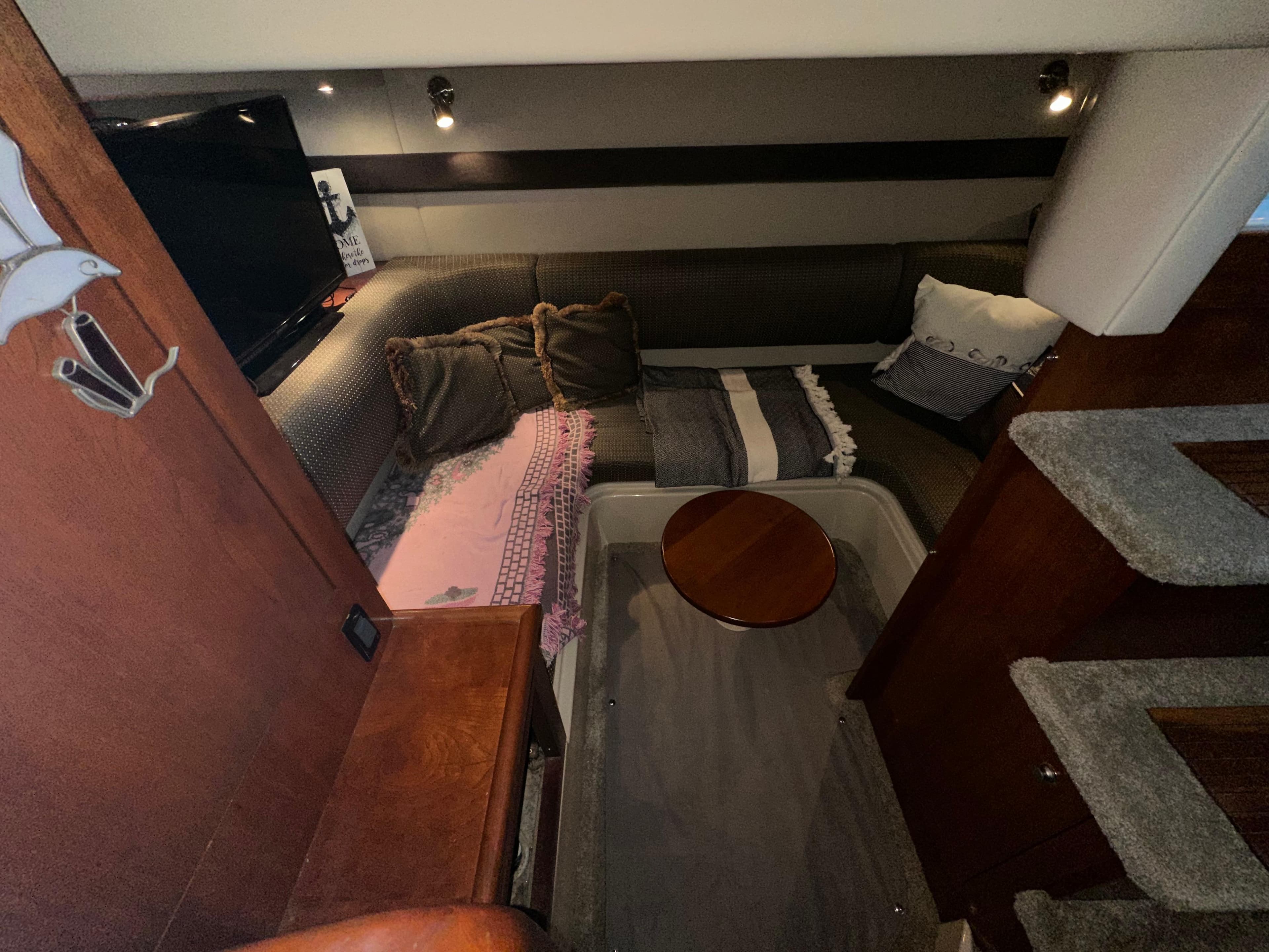 2005 Cruisers Yachts 340 Express interior with cozy seating and wooden accents.