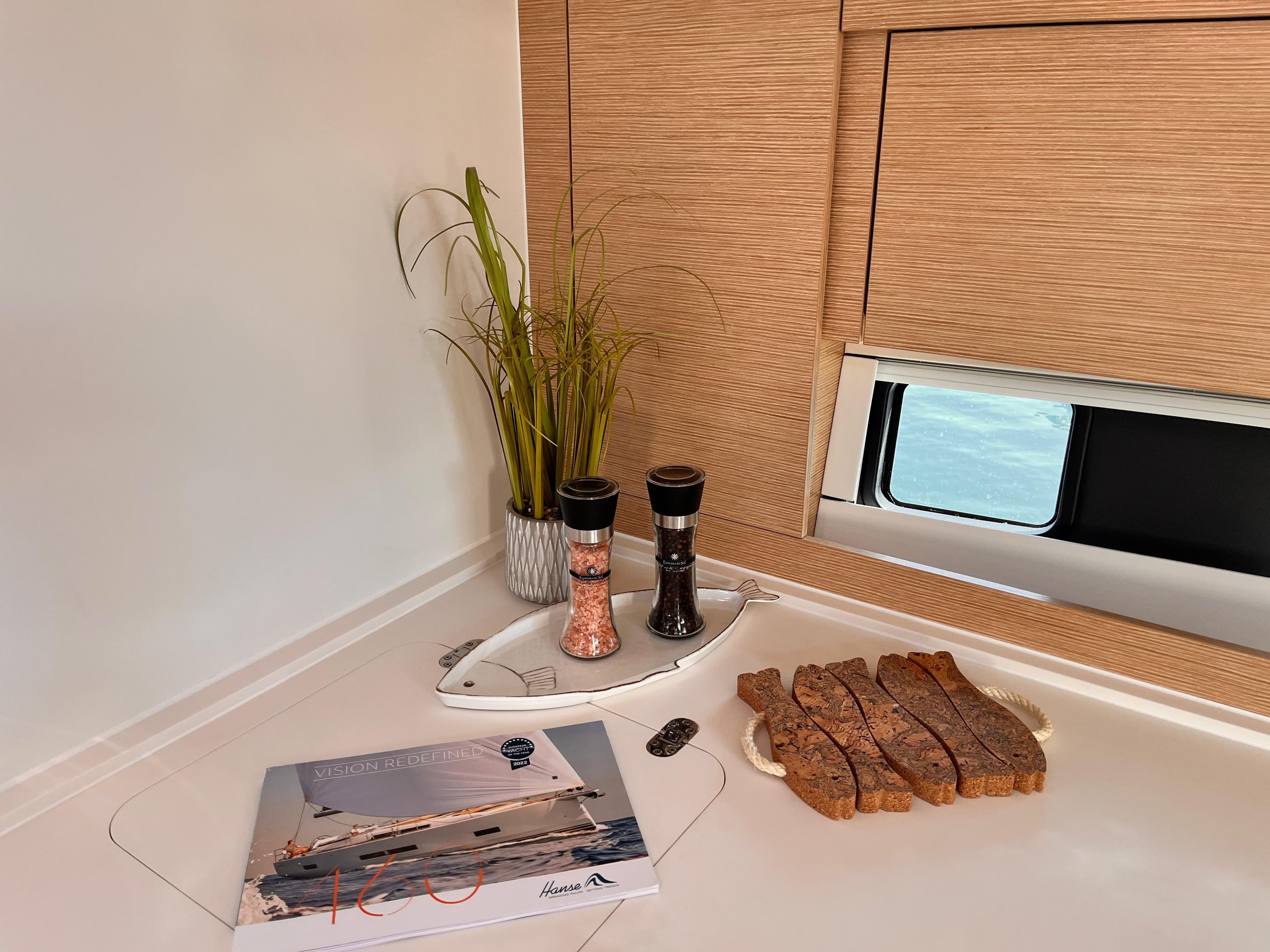 Interior of 2023 Hanse 460 yacht with bread, spices, and a brochure on the counter.