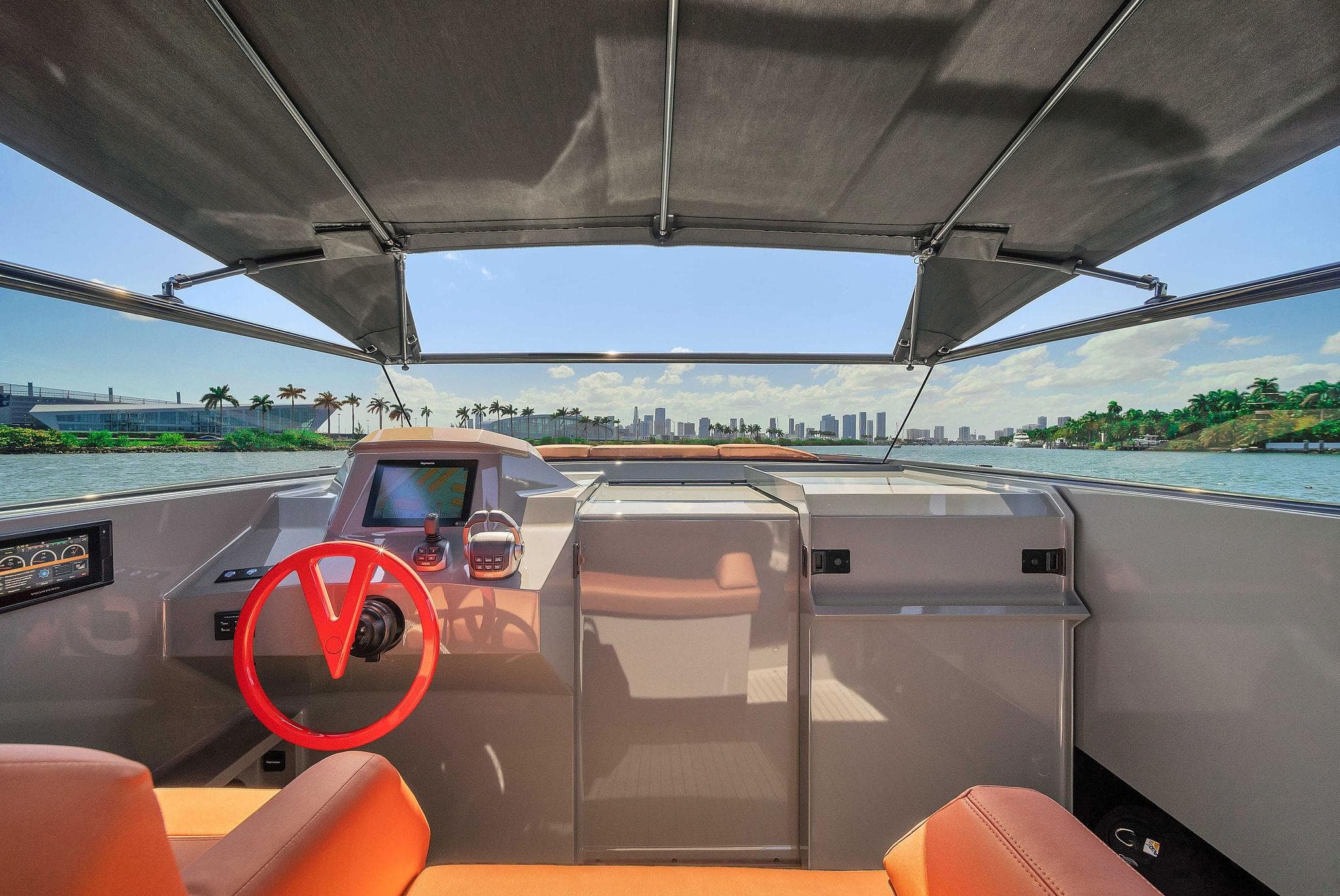 Interior view of 2021 Vanquish Yachts VQ 45 with red steering wheel and city skyline.