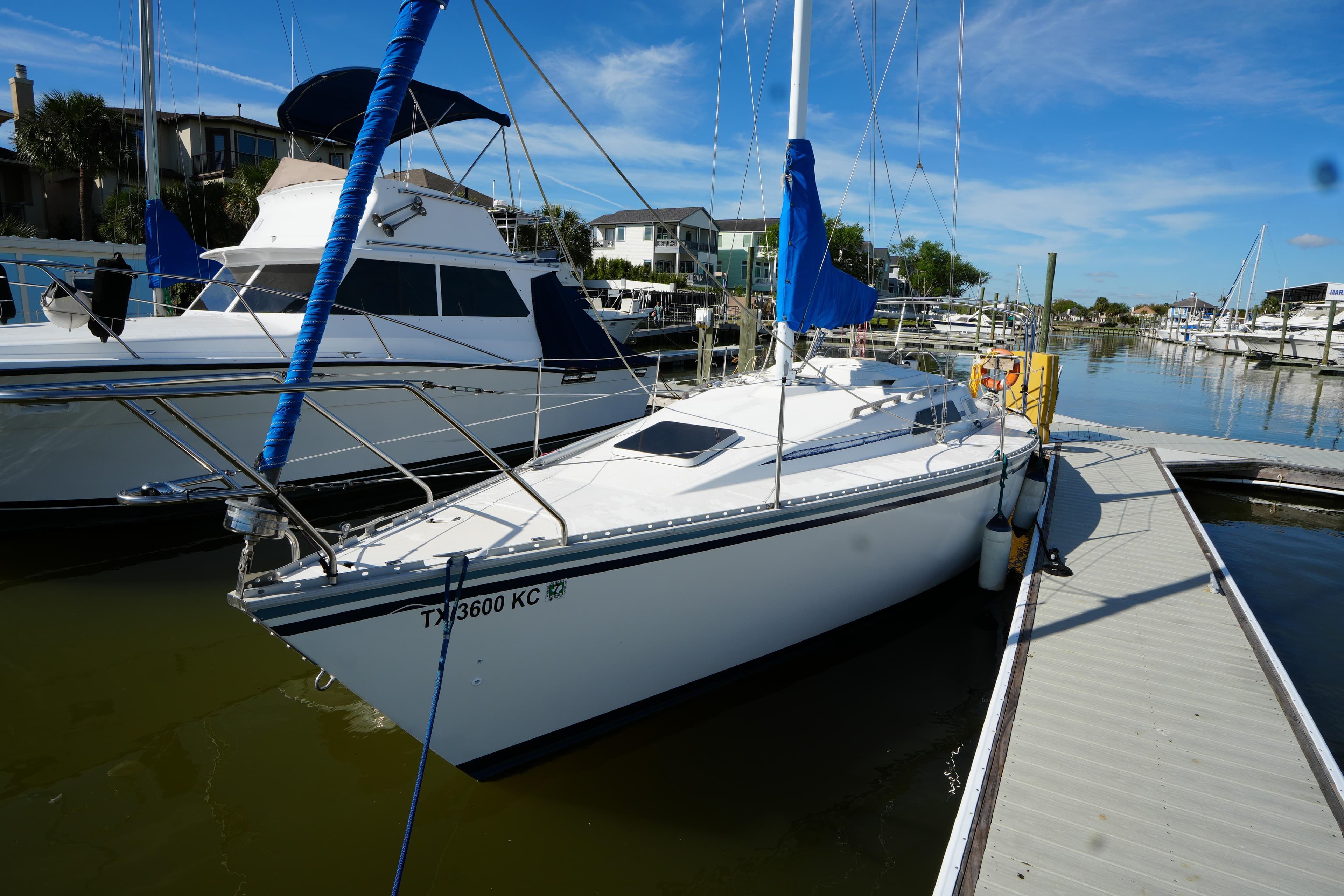 1986 Hunter 28.5 sailboat docked at marina under clear blue sky.
