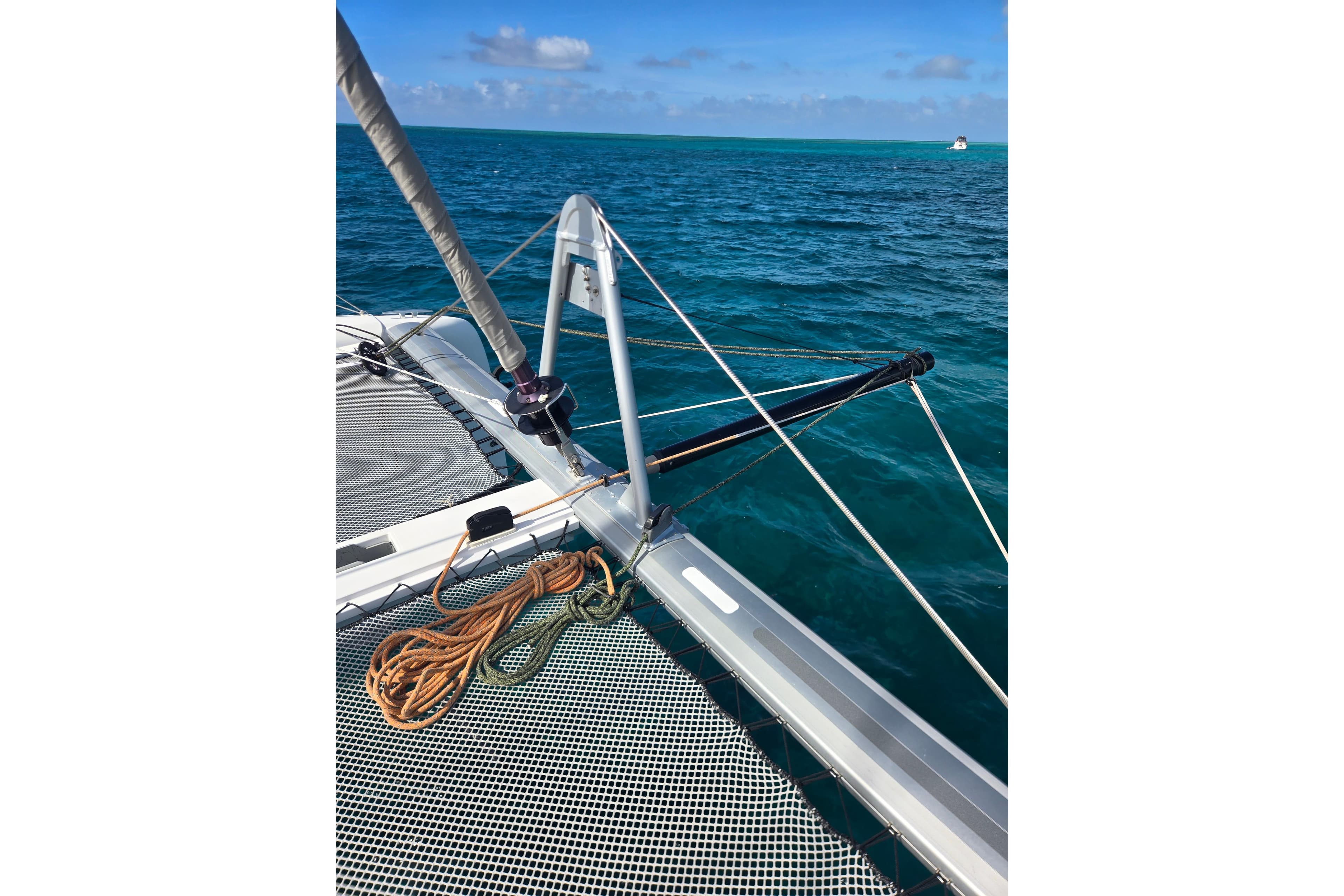 2016 Outremer 45 catamaran deck with ropes, sailing on clear blue ocean.