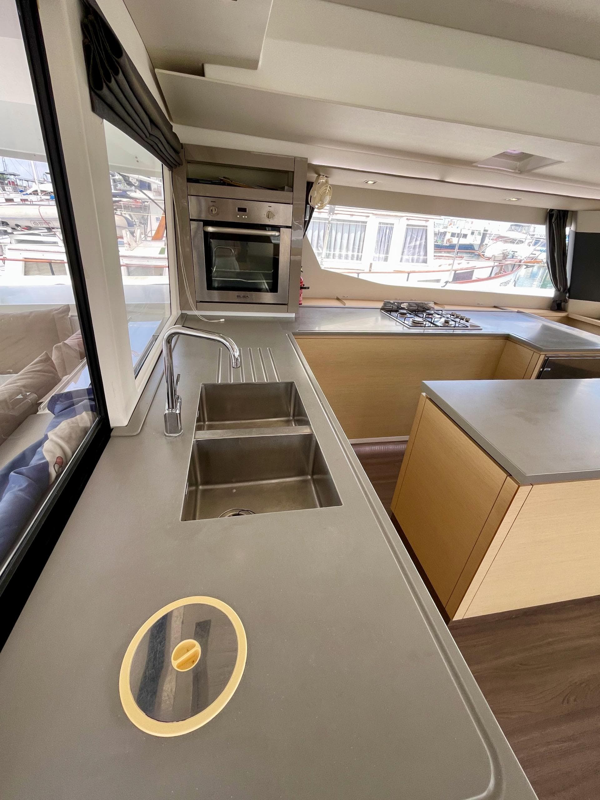 Modern kitchen interior of 2017 Fountaine Pajot SABA 50 catamaran with sleek countertops and appliances.