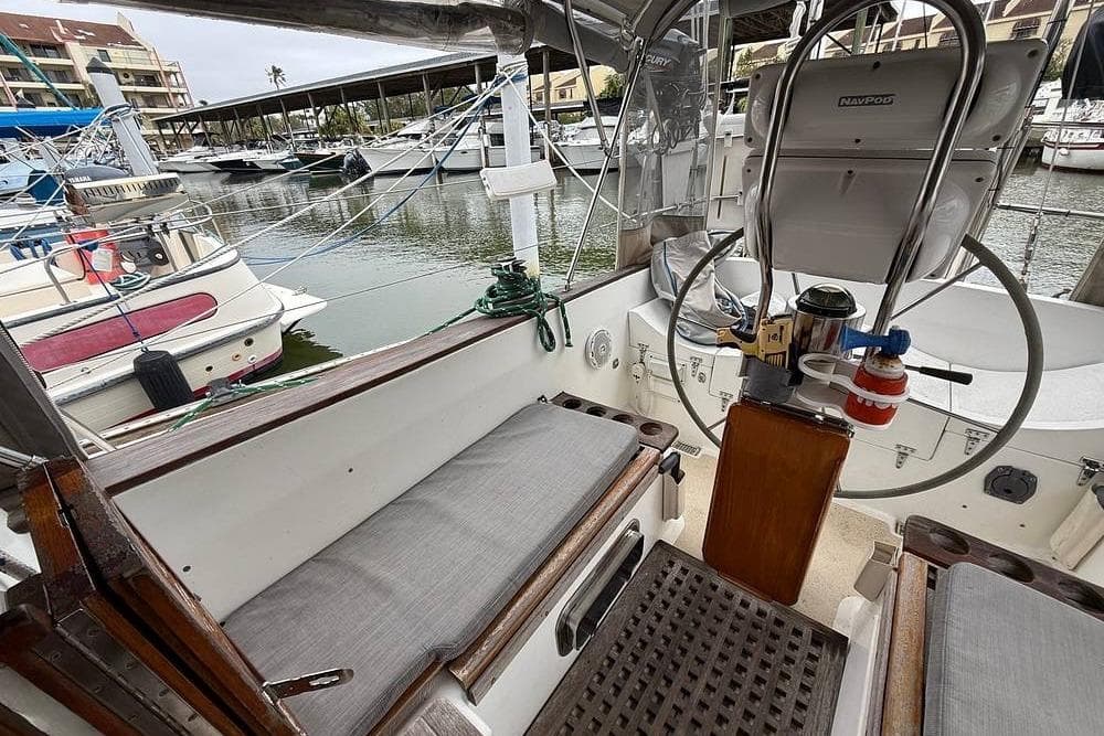 1984 Morgan 384 sailboat cockpit with steering wheel, docked in marina.