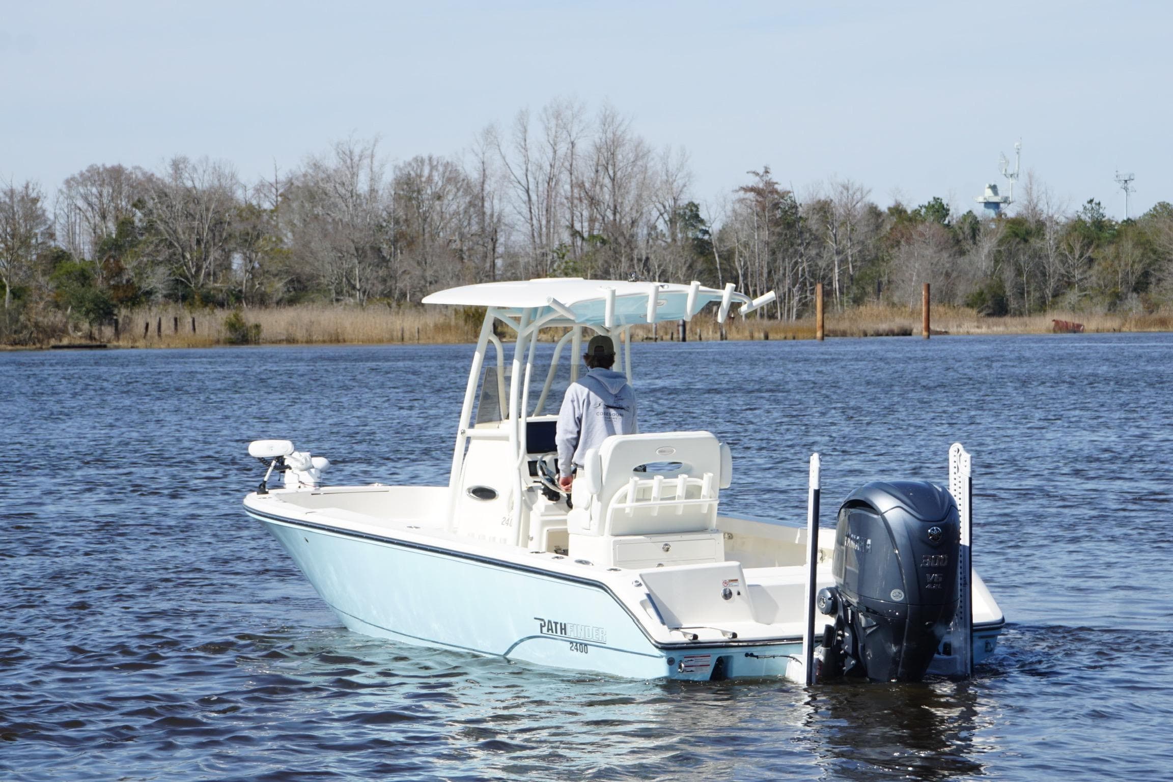 2023 Pathfinder 2400 TRS boat cruising on a calm river with trees in the background.
