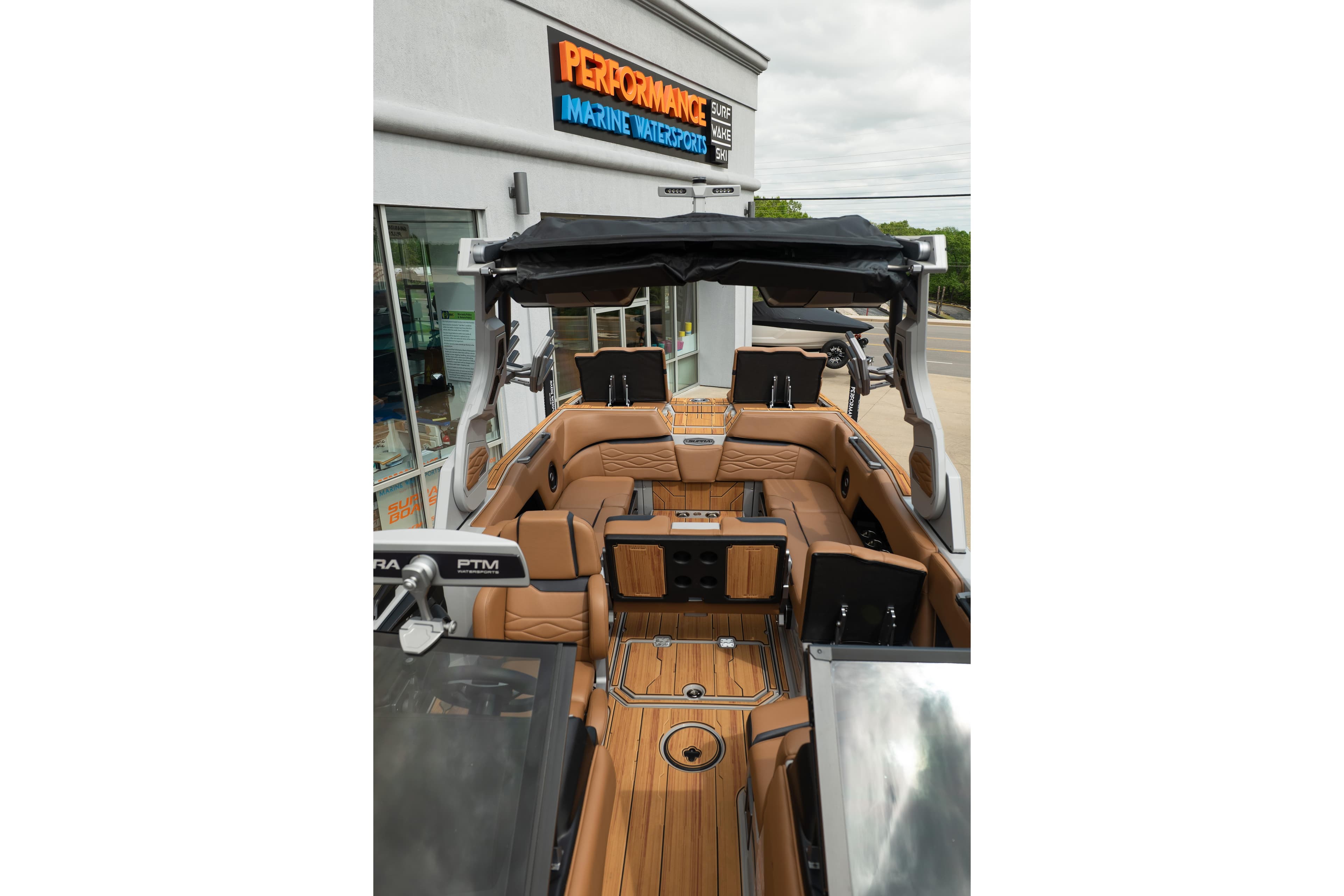 2025 Supra SE 550 boat interior with luxurious tan seating and sleek design at a marine dealership.