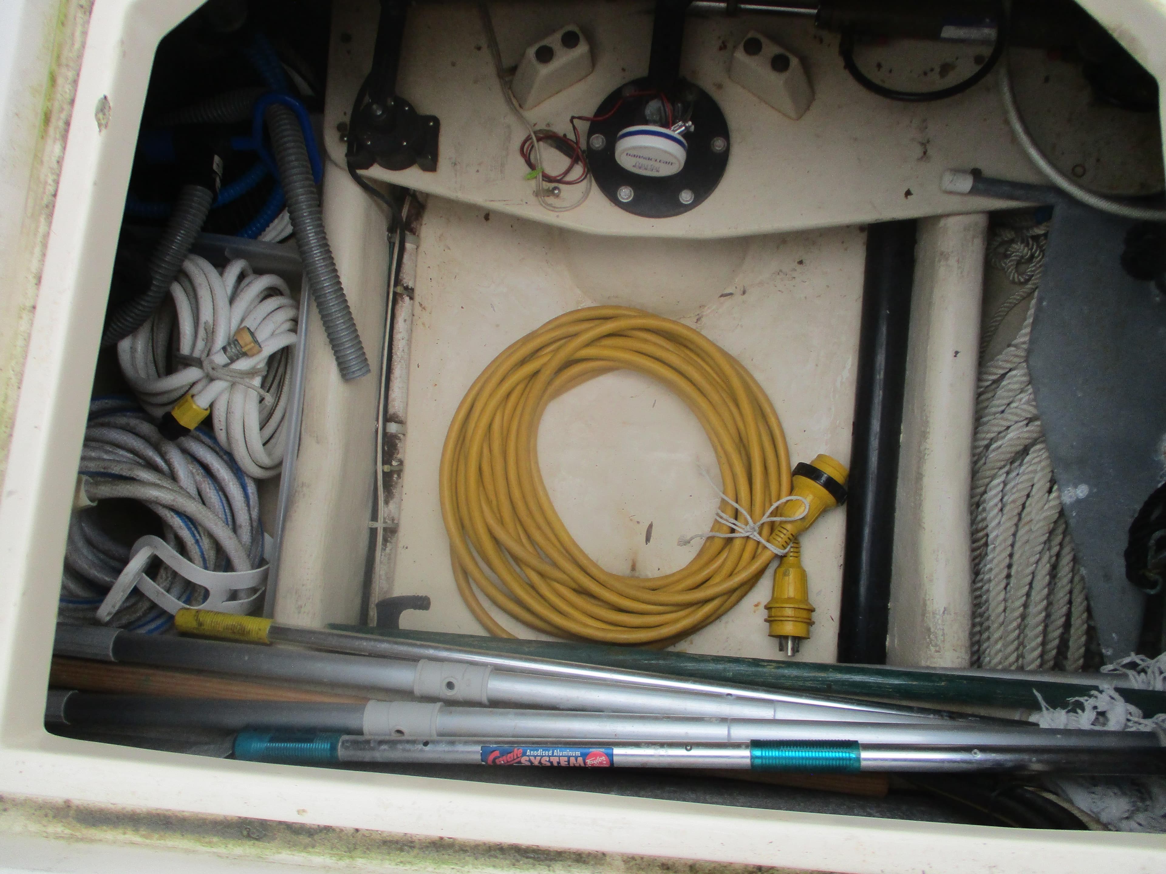 Storage compartment of a 1998 Nordic Tug 32 with ropes, cables, and equipment.