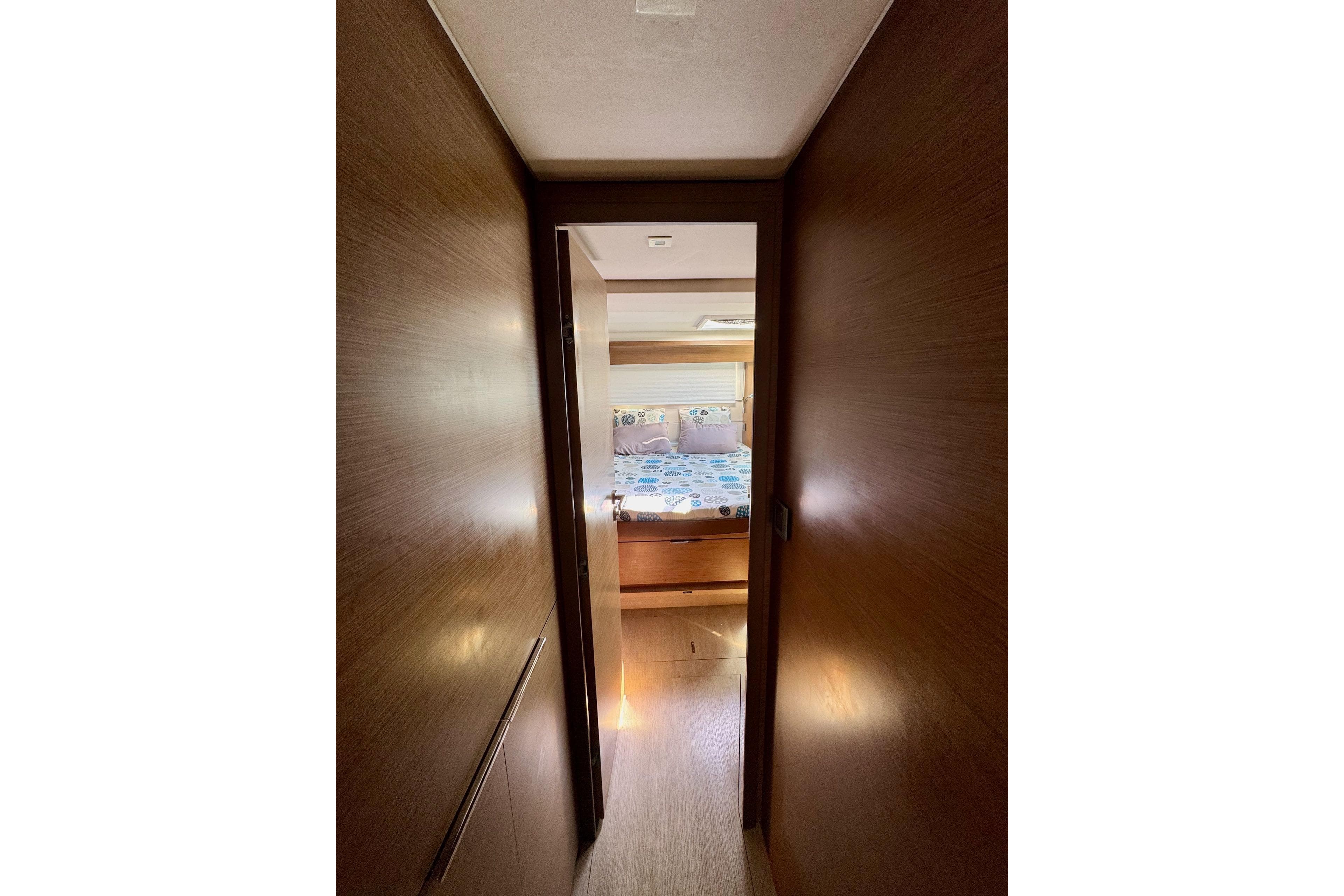 Interior hallway view of 2018 Lagoon 50 yacht, leading to a cozy bedroom.