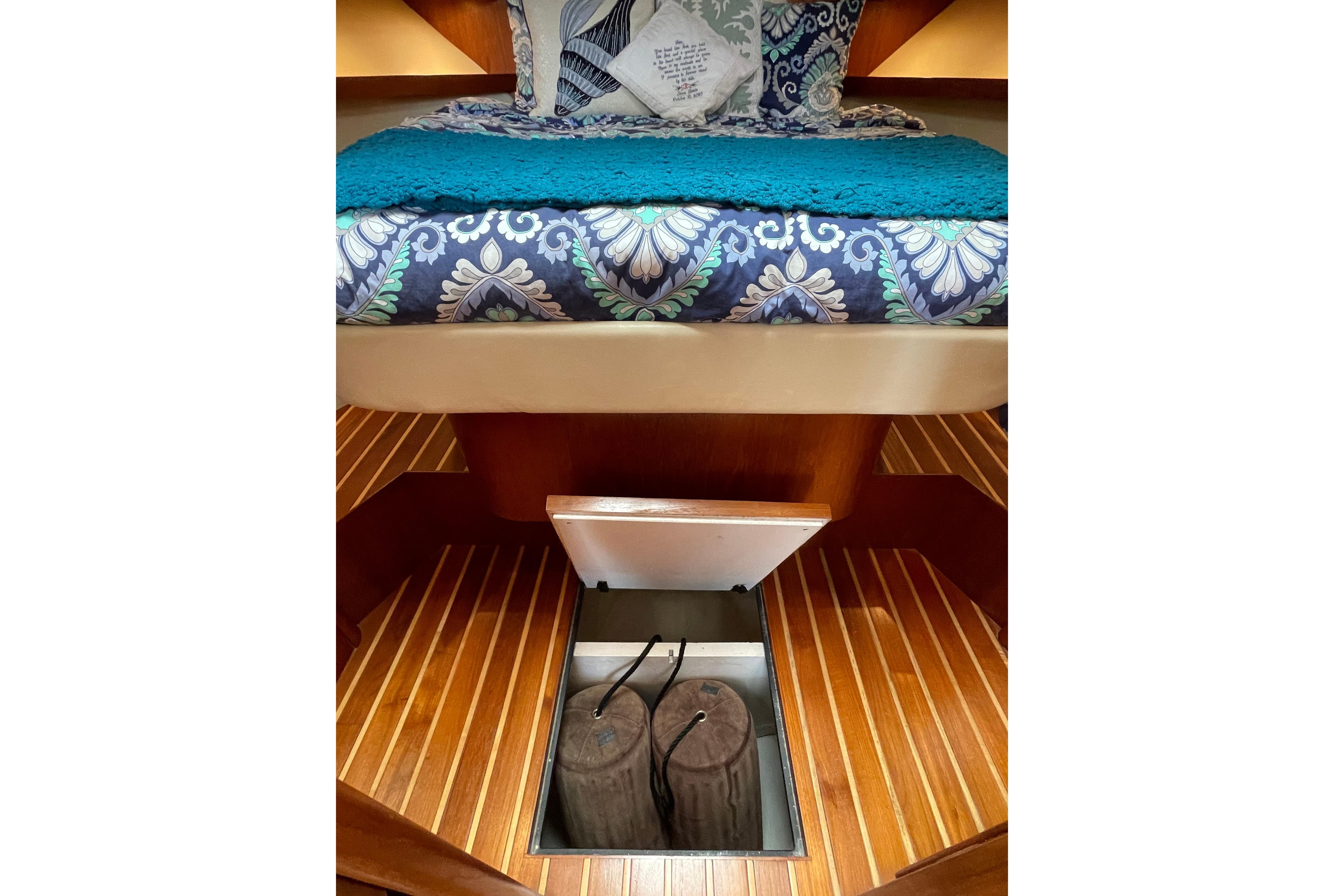 2009 Tiara Yachts 4200 Open cabin with patterned bedding and underfloor storage.