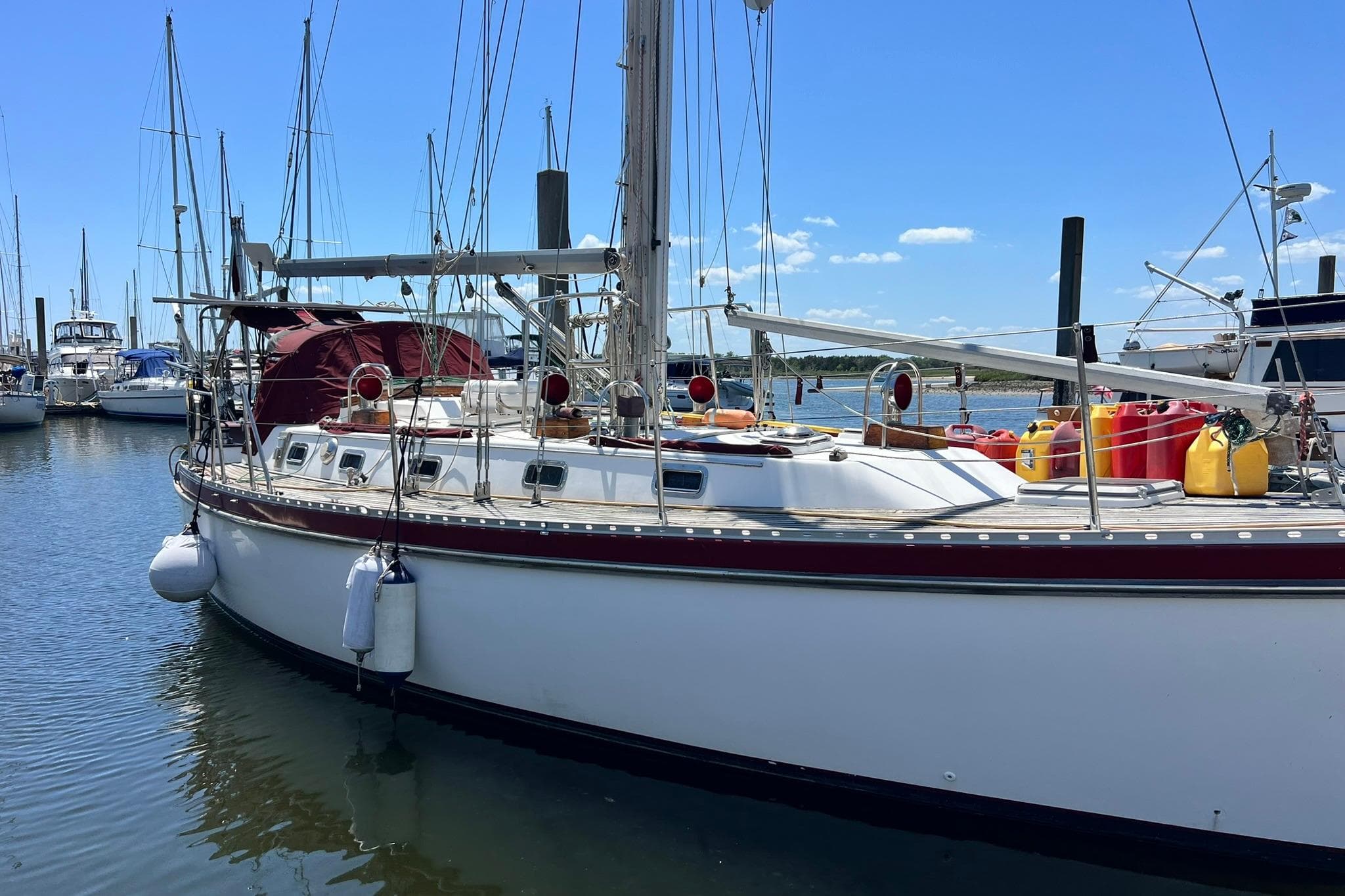 1988 Tayana Vancouver 42 sailboat docked in sunny harbor.