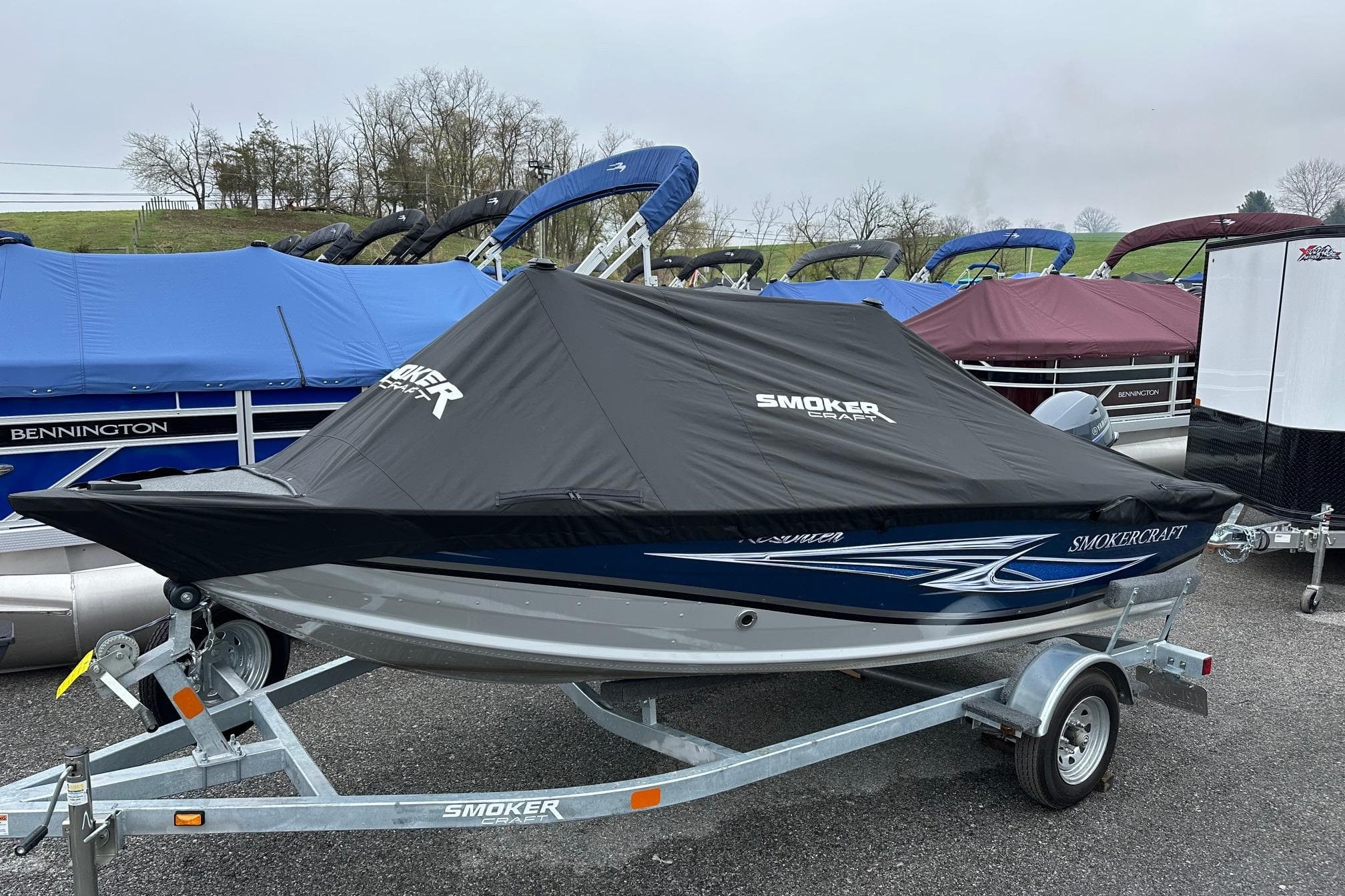 2025 Smoker Craft Resorter 151 boat on trailer, covered, parked outdoors.