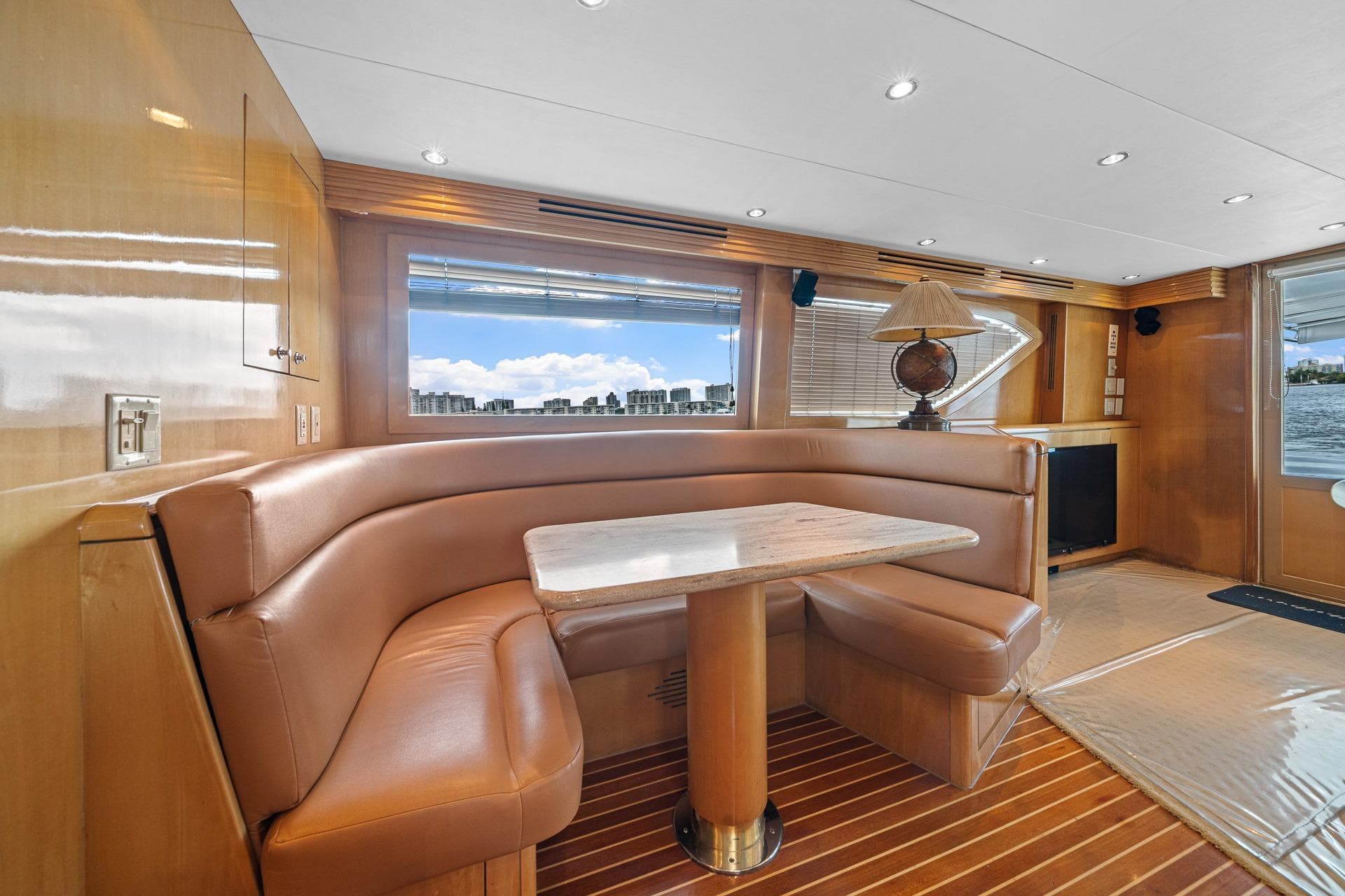 Luxurious interior of 2002 Hatteras 60 Convertible yacht with leather seating and wooden finishes.