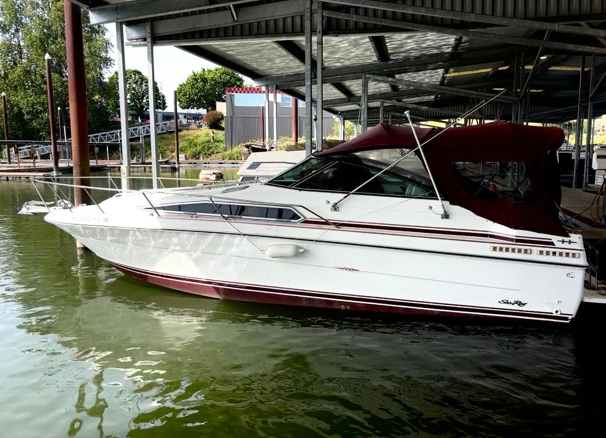 1989 Sea Ray Sundancer boat docked under a covered marina.