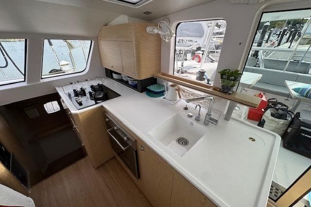 Modern kitchen interior of 2021 Outremer 51 yacht with sleek design and appliances.