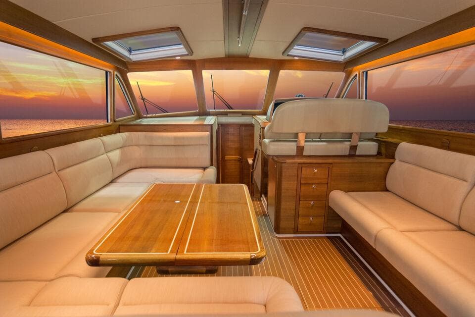 Luxurious interior of 2025 Eastbay EB44 yacht with sunset view through windows.