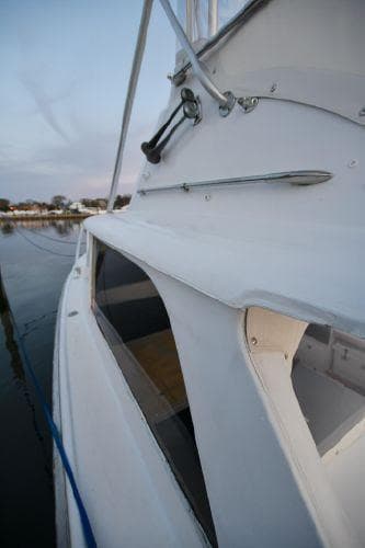 1965 Bertram Sportfisher boat docked, showcasing sleek white exterior design.