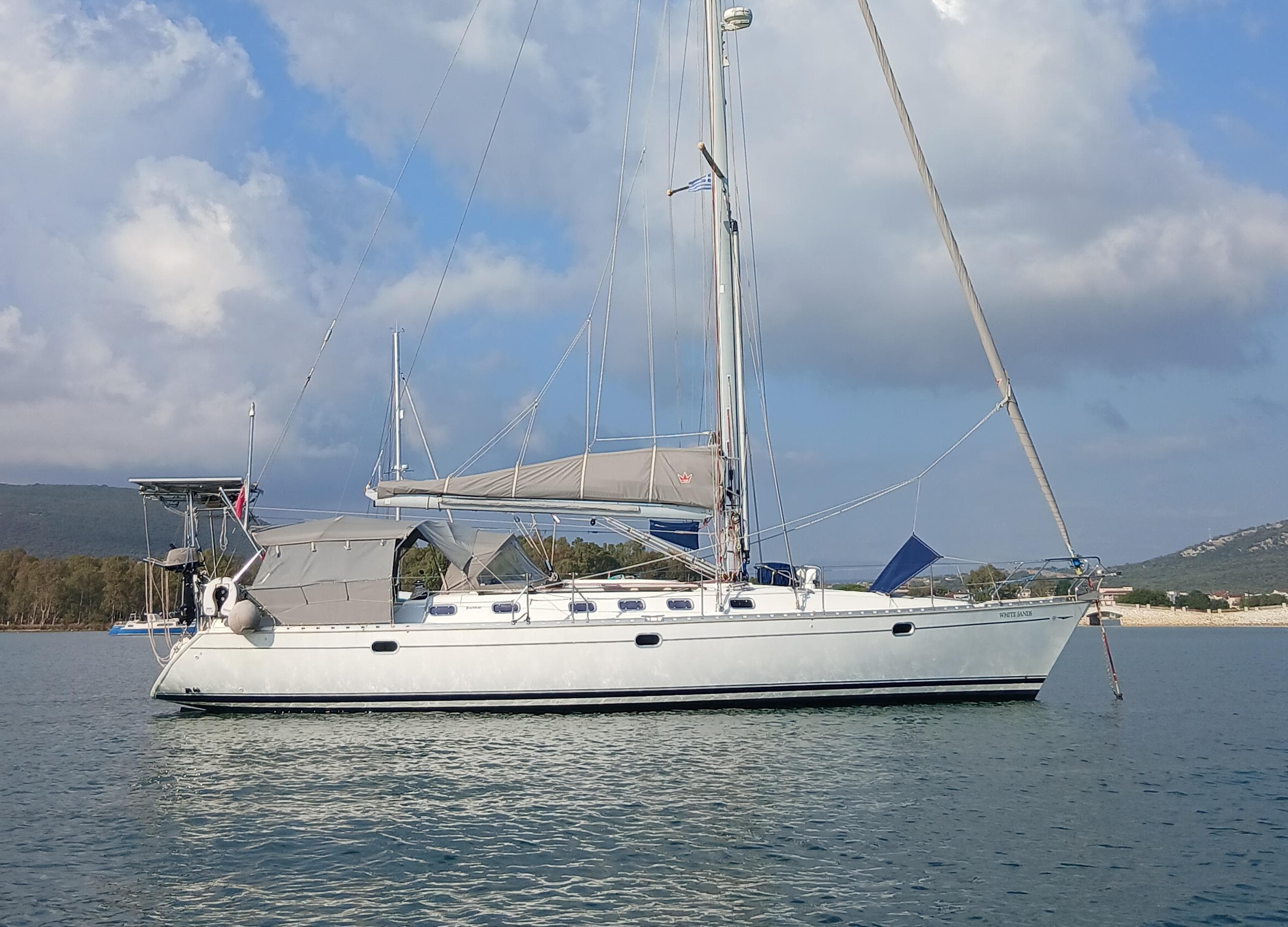 Jeanneau Sun Odyssey 45.2 sailboat from 2000 anchored on calm water.