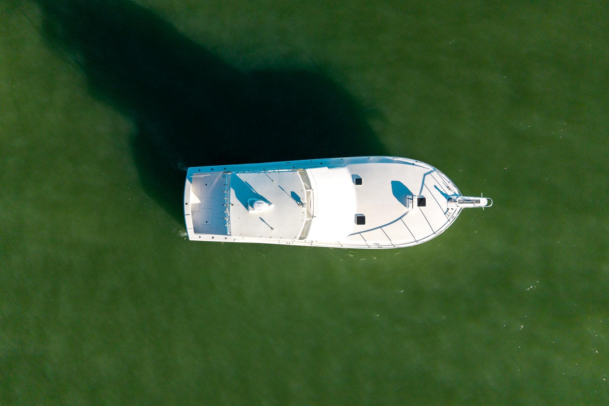 Aerial view of 1998 Viking 50 Convertible yacht on green water.