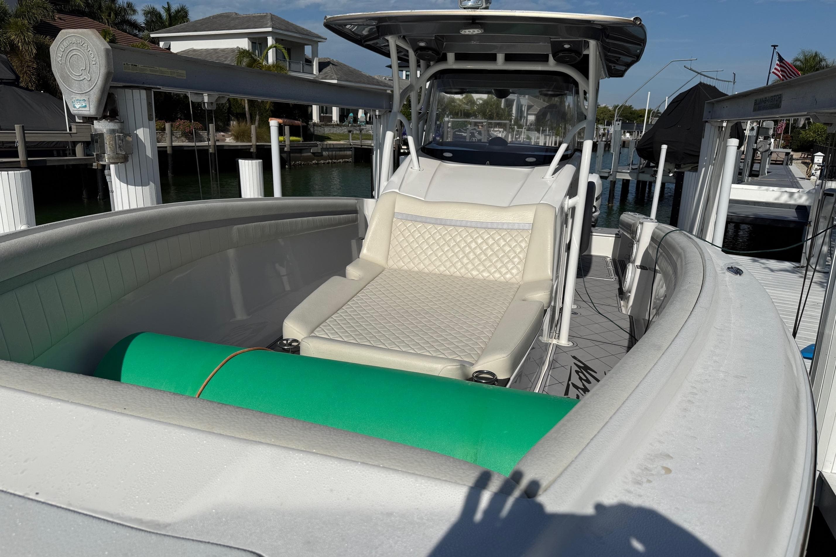 2014 Nor-Tech 340 Sport Center Console boat with cushioned seating and docked in a marina.