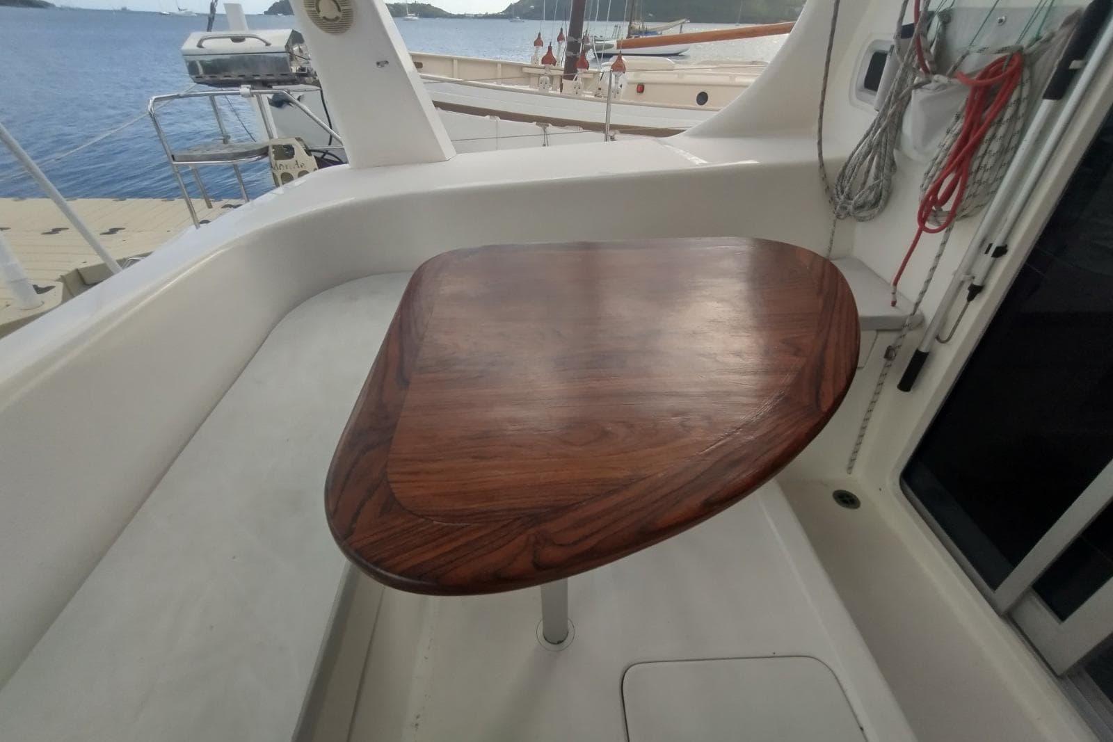 Wooden table on 2001 Maxim Yachts 380, docked by the sea.