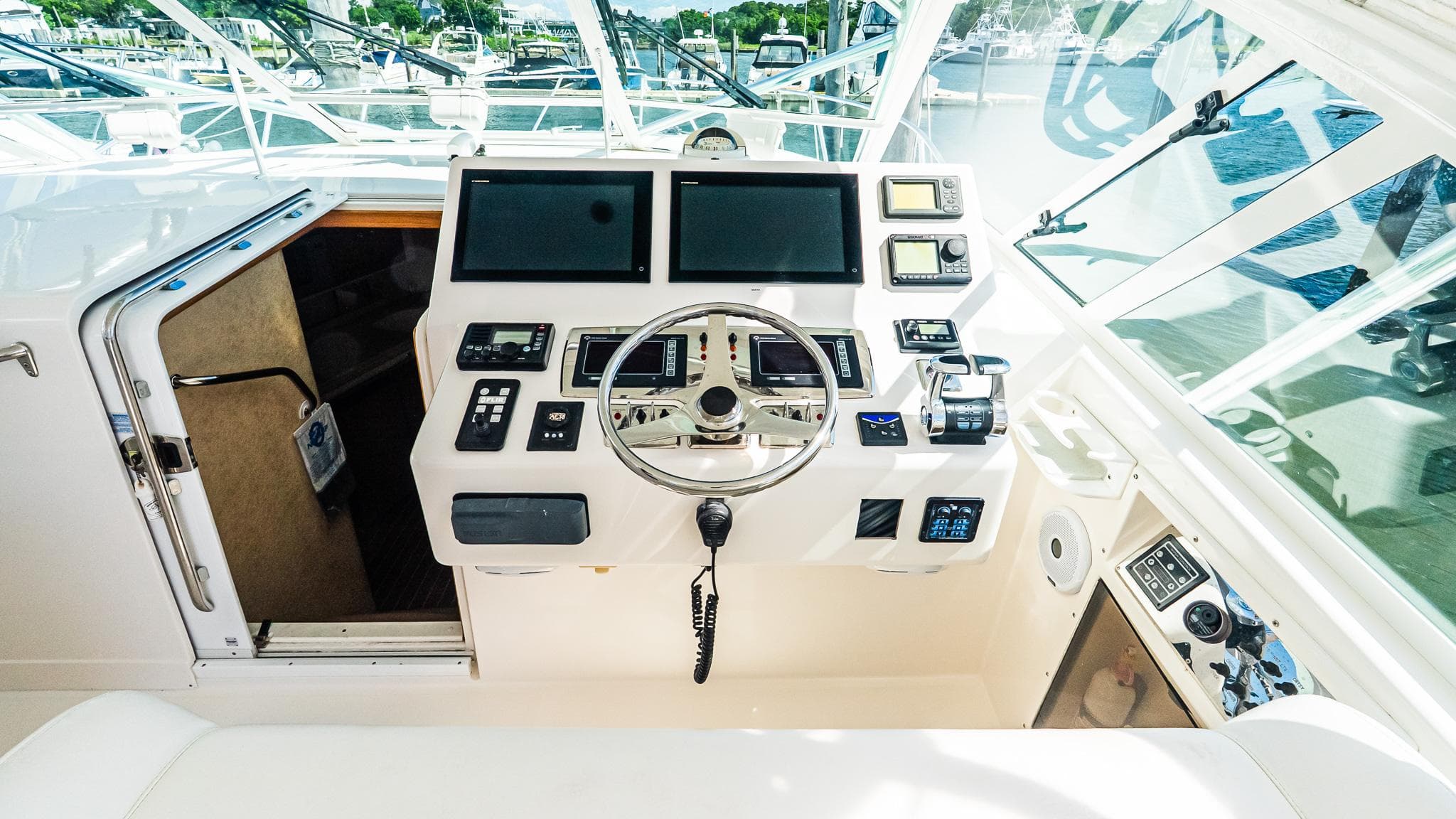 2008 Cabo 38 Express helm with modern navigation equipment and steering wheel, docked at marina.
