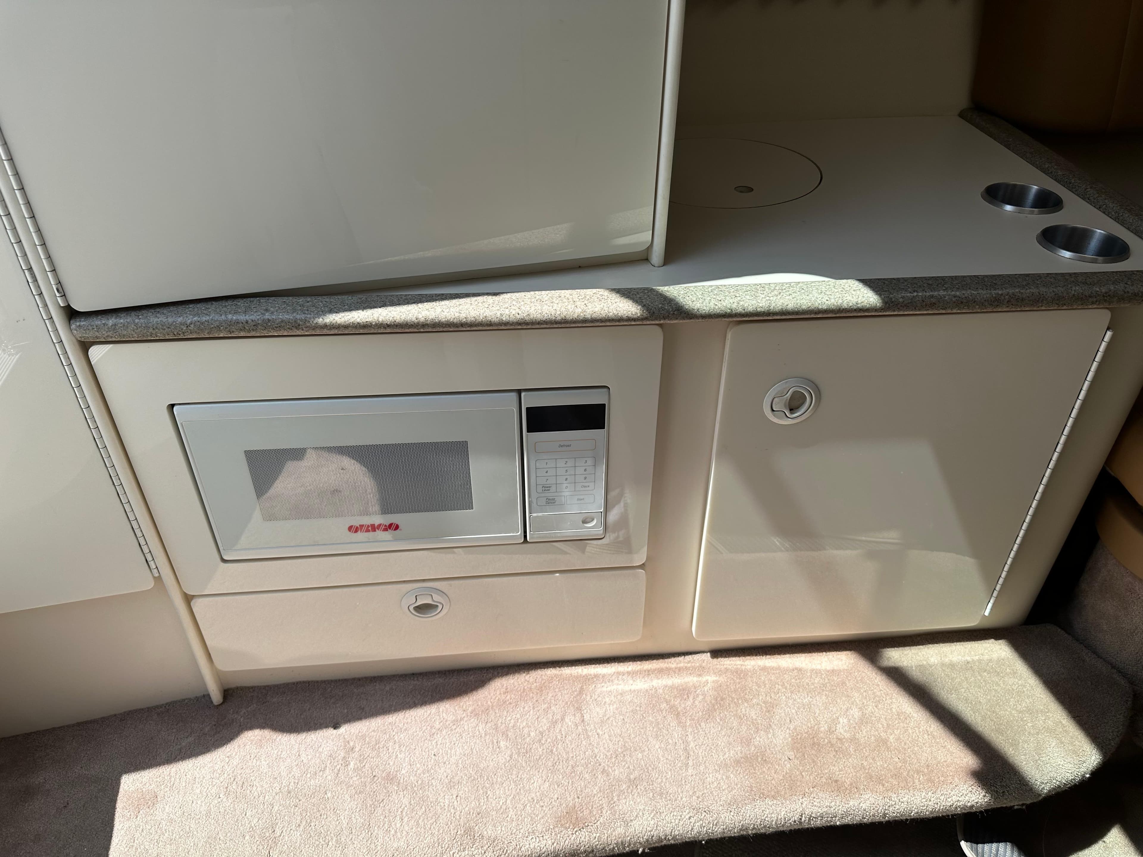 Interior of a 2000 Formula 330 SS boat featuring a built-in microwave and storage cabinets.