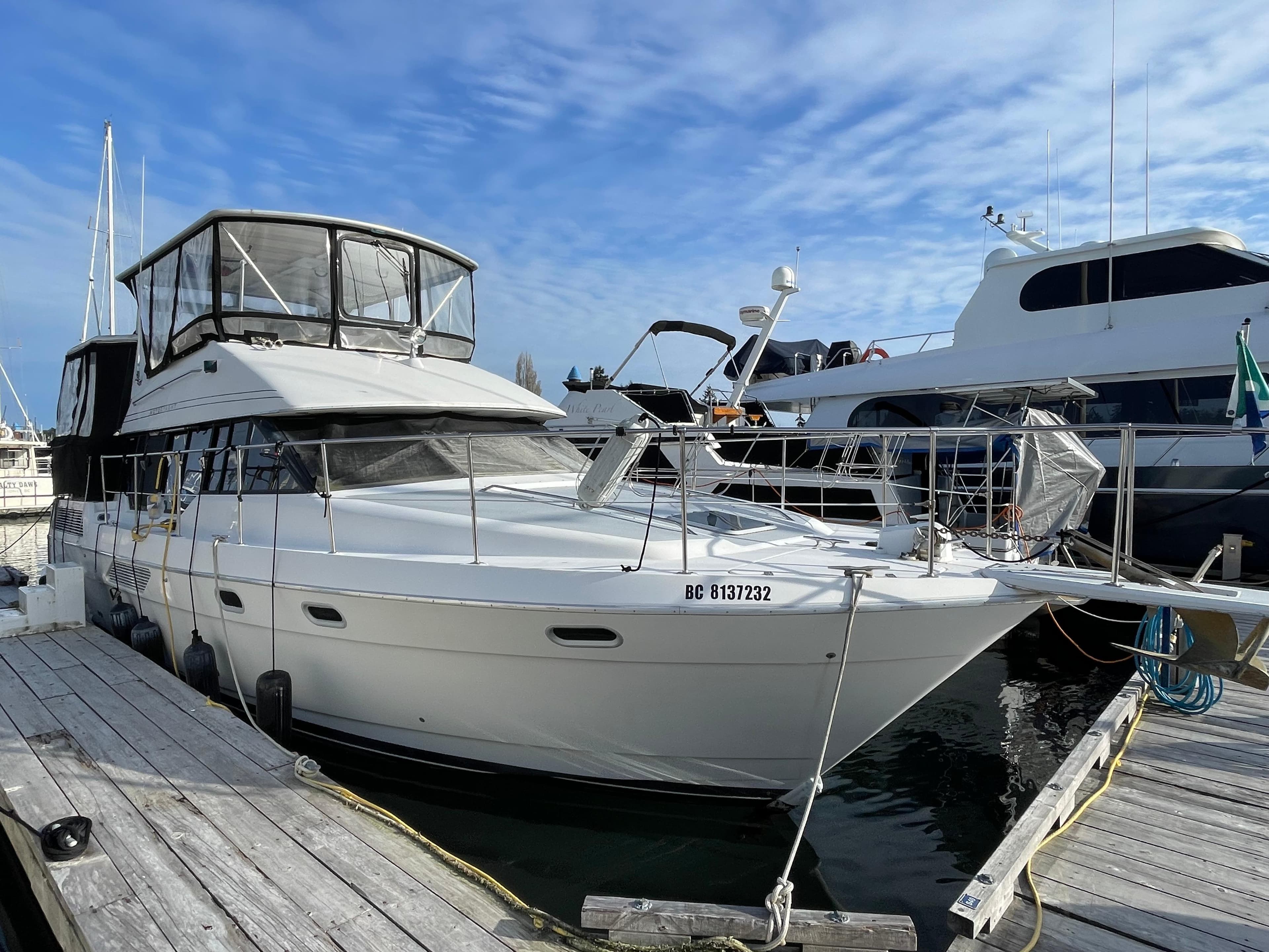 1991 Bayliner 4387 yacht docked at marina under blue sky.