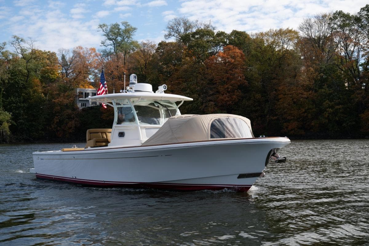 2016 Hunt Yachts 32 Center Console on a scenic lake with autumn trees.
