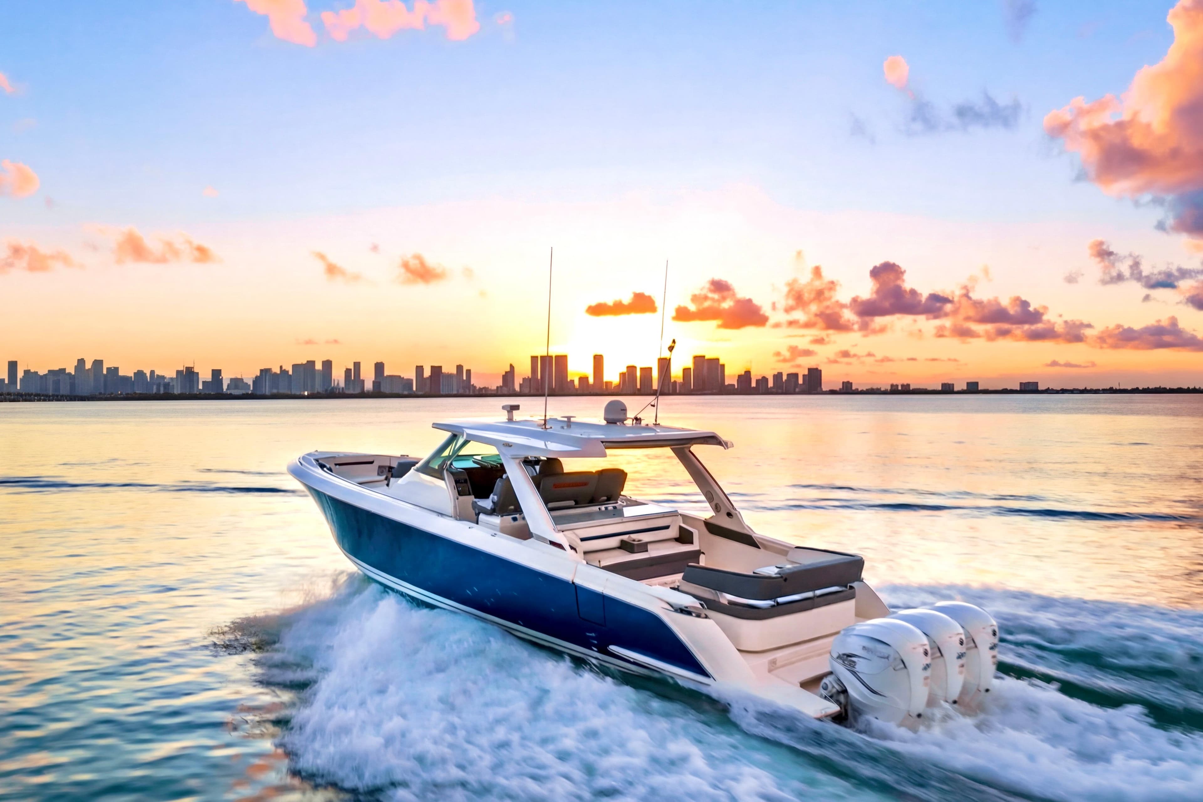 2020 Tiara Yachts 43 LS cruising at sunset with city skyline backdrop.