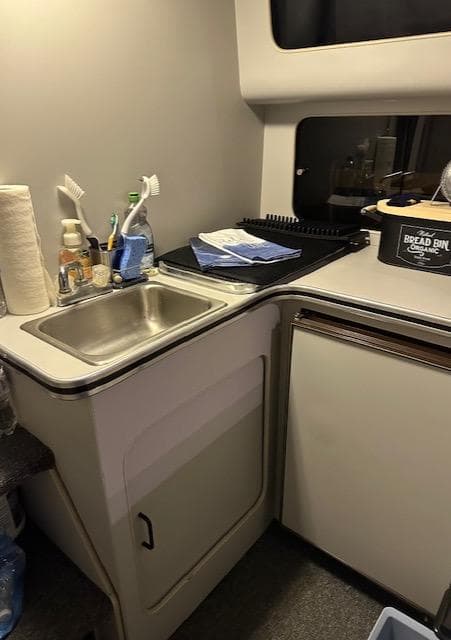 1987 Chris-Craft 320 Amerosport kitchen area with sink, counter, and storage.