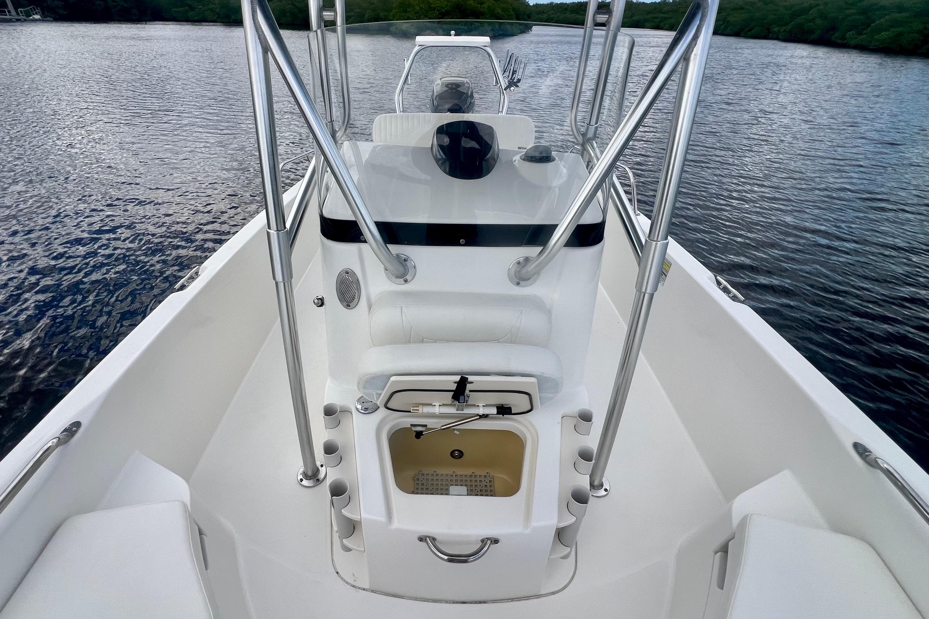 2009 Boston Whaler 230 Dauntless boat interior with console and seating on calm water.
