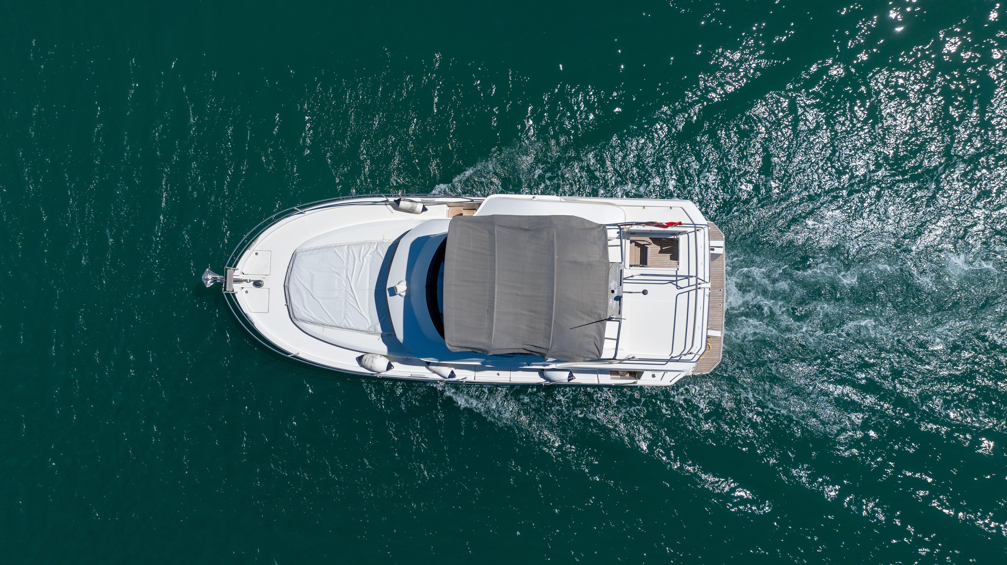 Aerial view of 2022 Beneteau Swift Trawler 35 cruising on clear blue water.