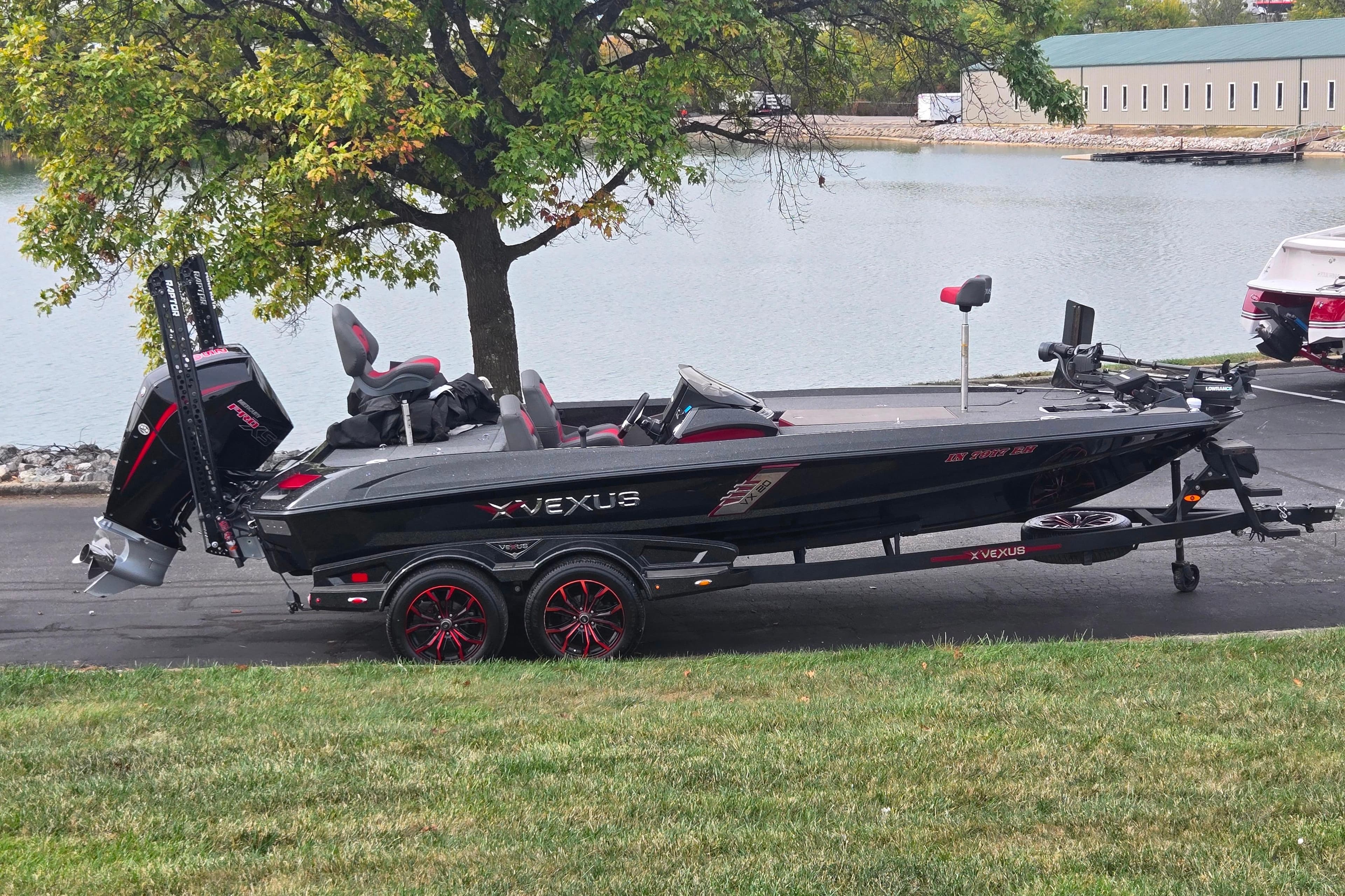 2022 Vexus VX20 boat on trailer by a lakeside, under a tree.