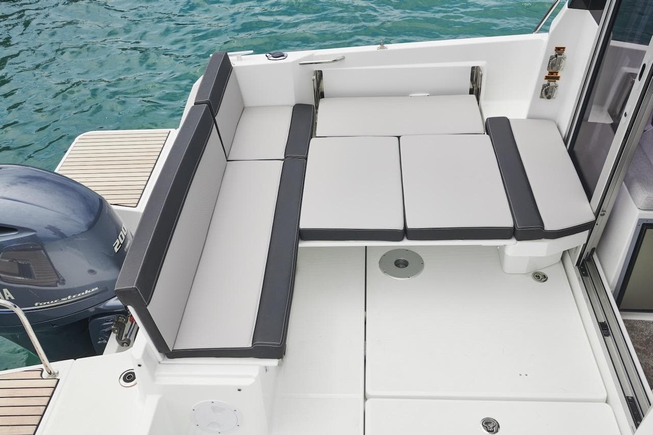 2025 Jeanneau NC 795 Series 2 boat with cushioned seating and Yamaha outboard motor.