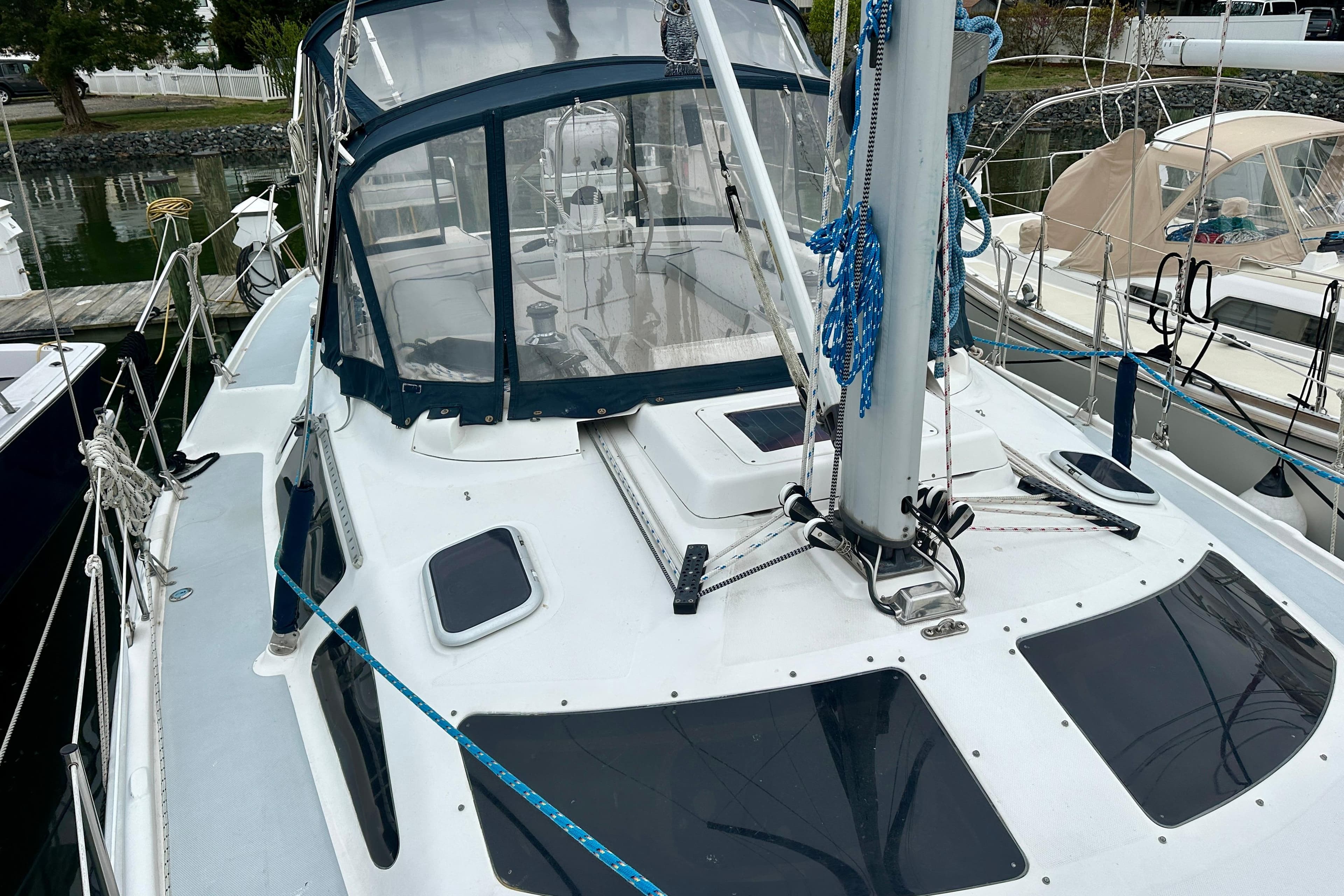 2002 Hunter Passage 420 sailboat docked, featuring a sleek deck and blue canopy.