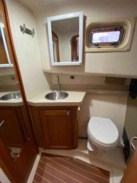 2004 Mainship 340 yacht bathroom with sink, mirror, and toilet.