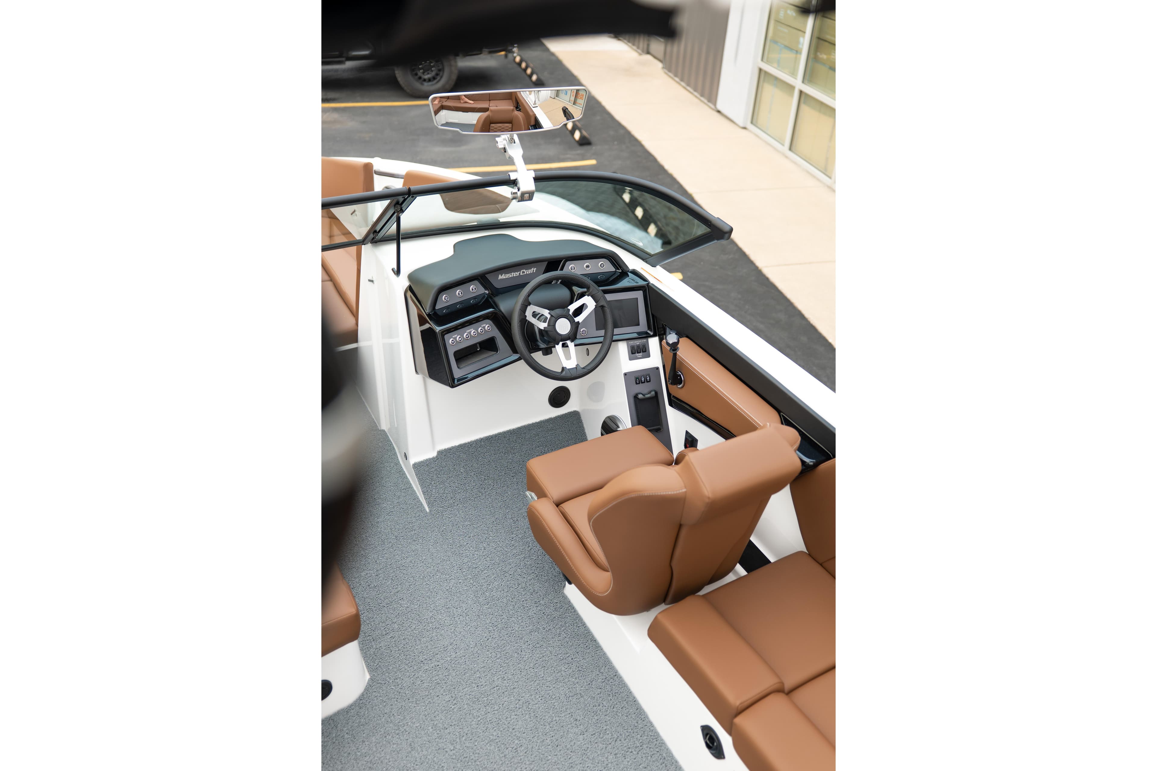 2026 MasterCraft NXT23 boat interior with brown seating and modern dashboard.