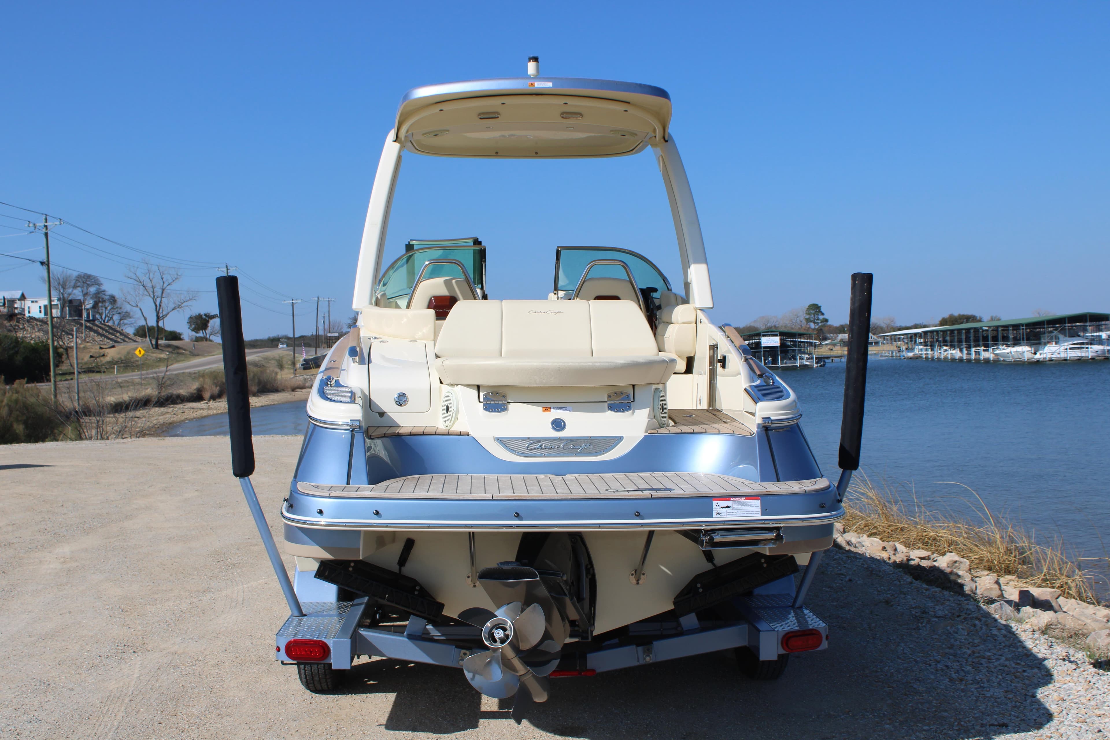 2025 Chris Craft Launch 28 GT boat on trailer by waterfront.