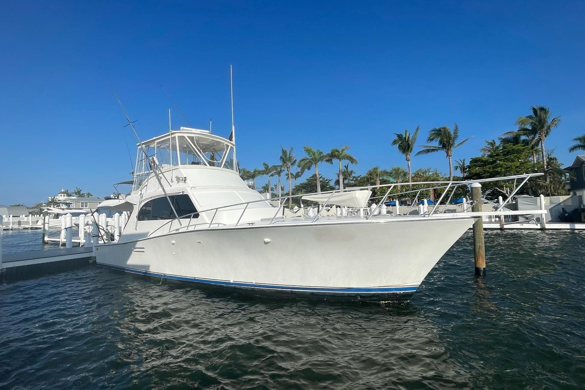 1988 Post 46 Sportfish yacht docked in sunny marina with palm trees.