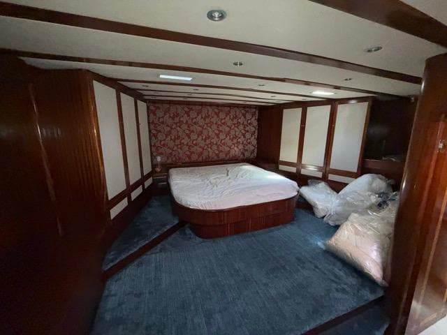Luxurious bedroom in 2006 Custom Made 42 M Motorsailor with wood paneling and plush carpet.