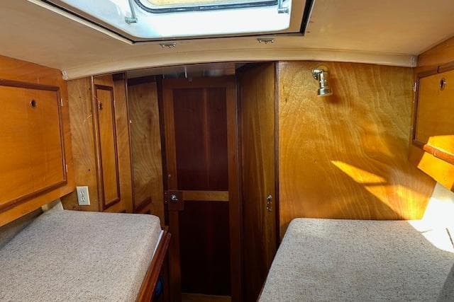 Interior of 1982 Chaser 39 sailboat with wooden cabinetry and twin berths.
