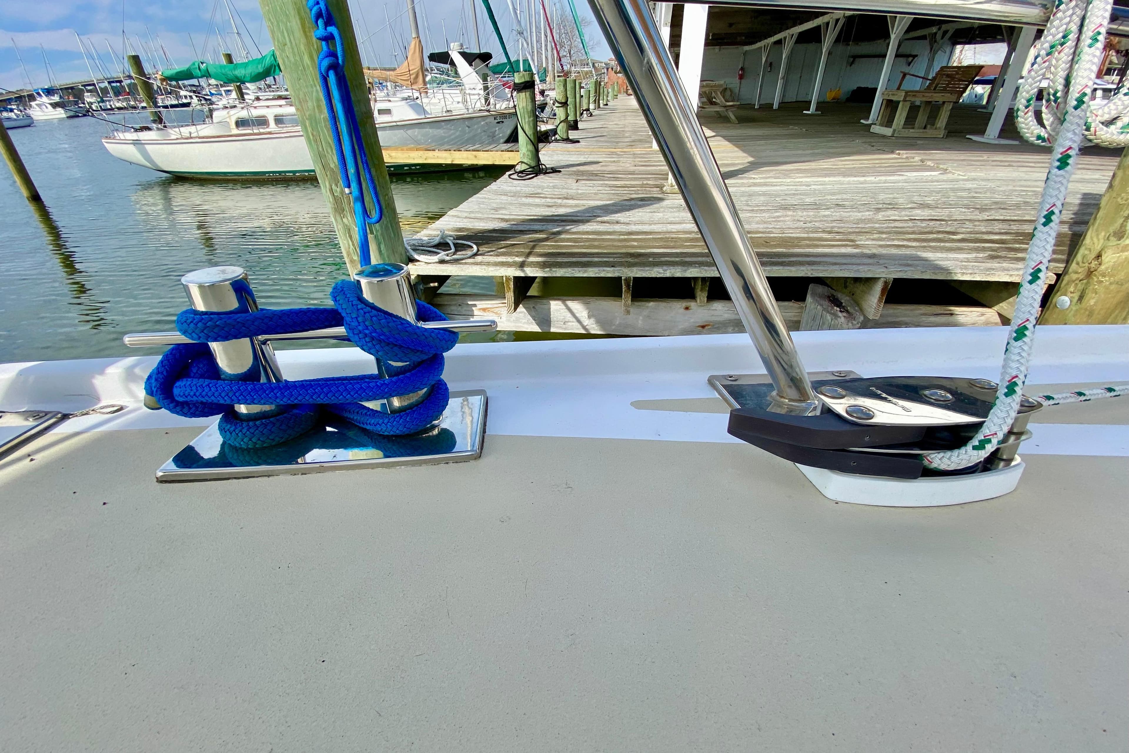 Sailboat deck with blue rope and cleat, Wellington 44, 1980 model, docked at marina.