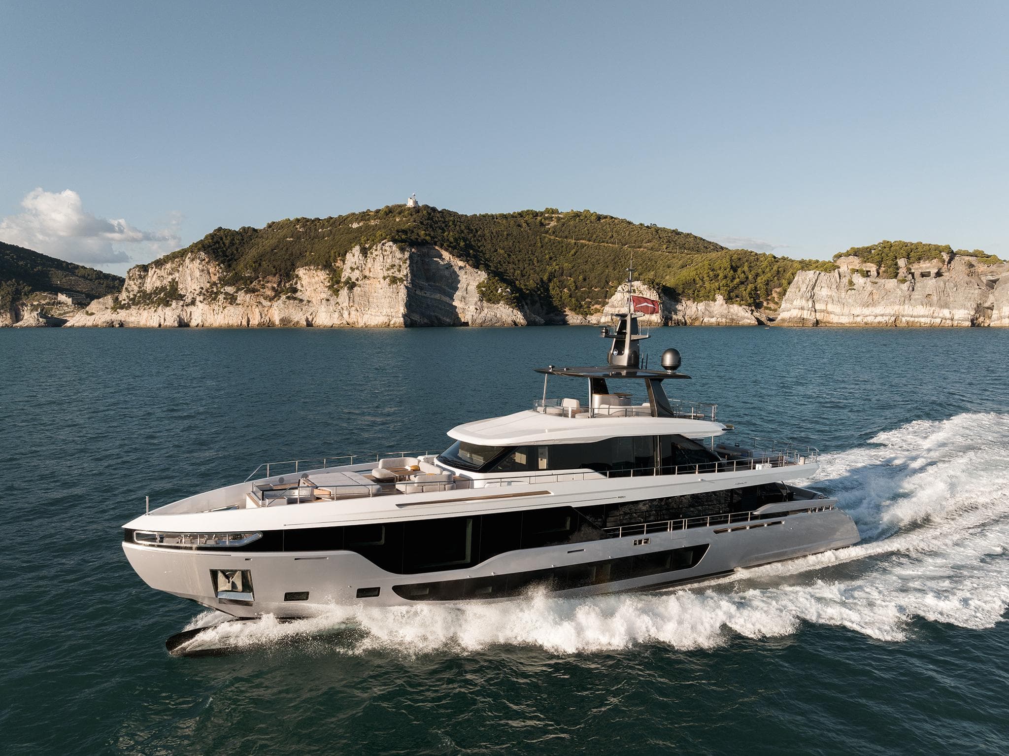 2024 Azimut Grande 36M yacht cruising near scenic coastal cliffs.