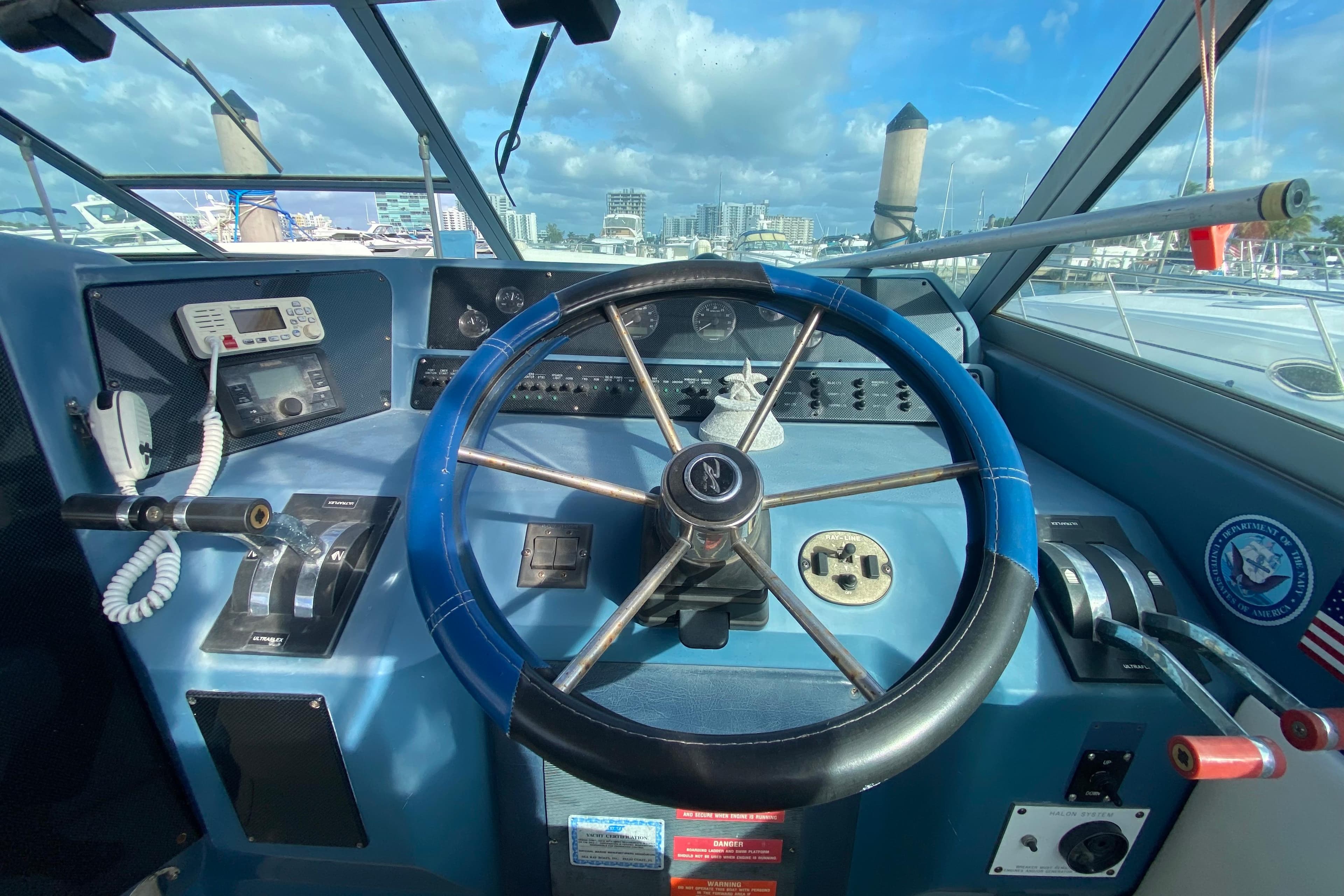 Cockpit of 1990 Sea Ray 420 Sundancer with steering wheel and control panel.