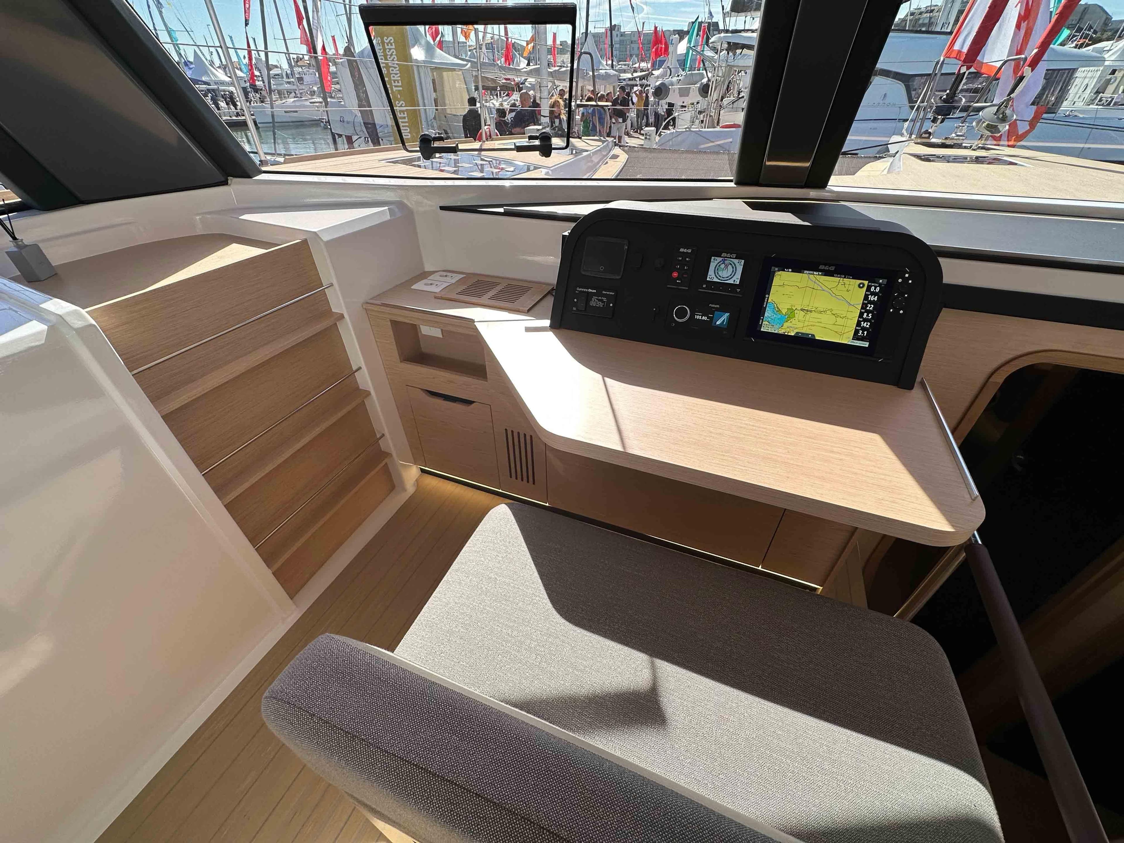 Modern NEEL 52 yacht interior with navigation system, wooden desk, and comfortable seating, 2025 model.
