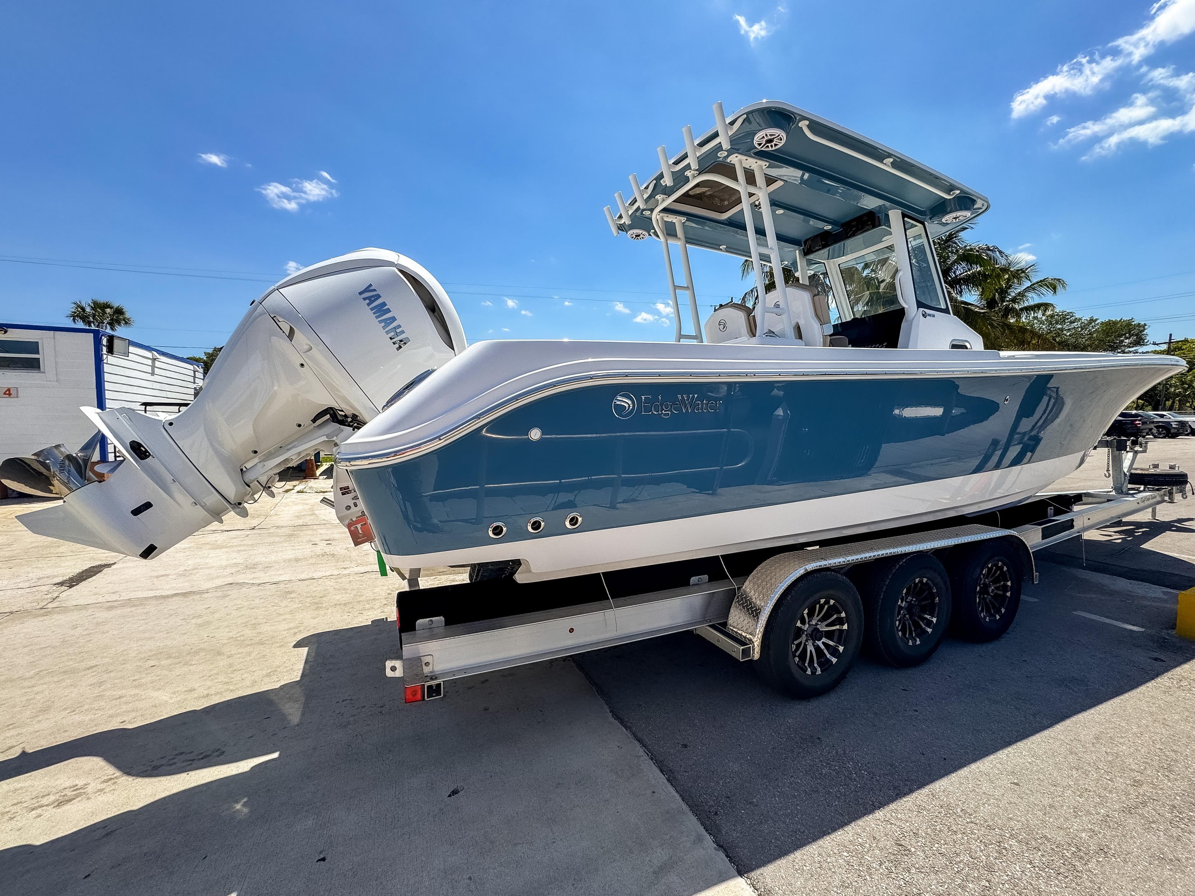 2025 Edgewater 325CC boat on trailer, featuring Yamaha outboard motor, under clear blue sky.