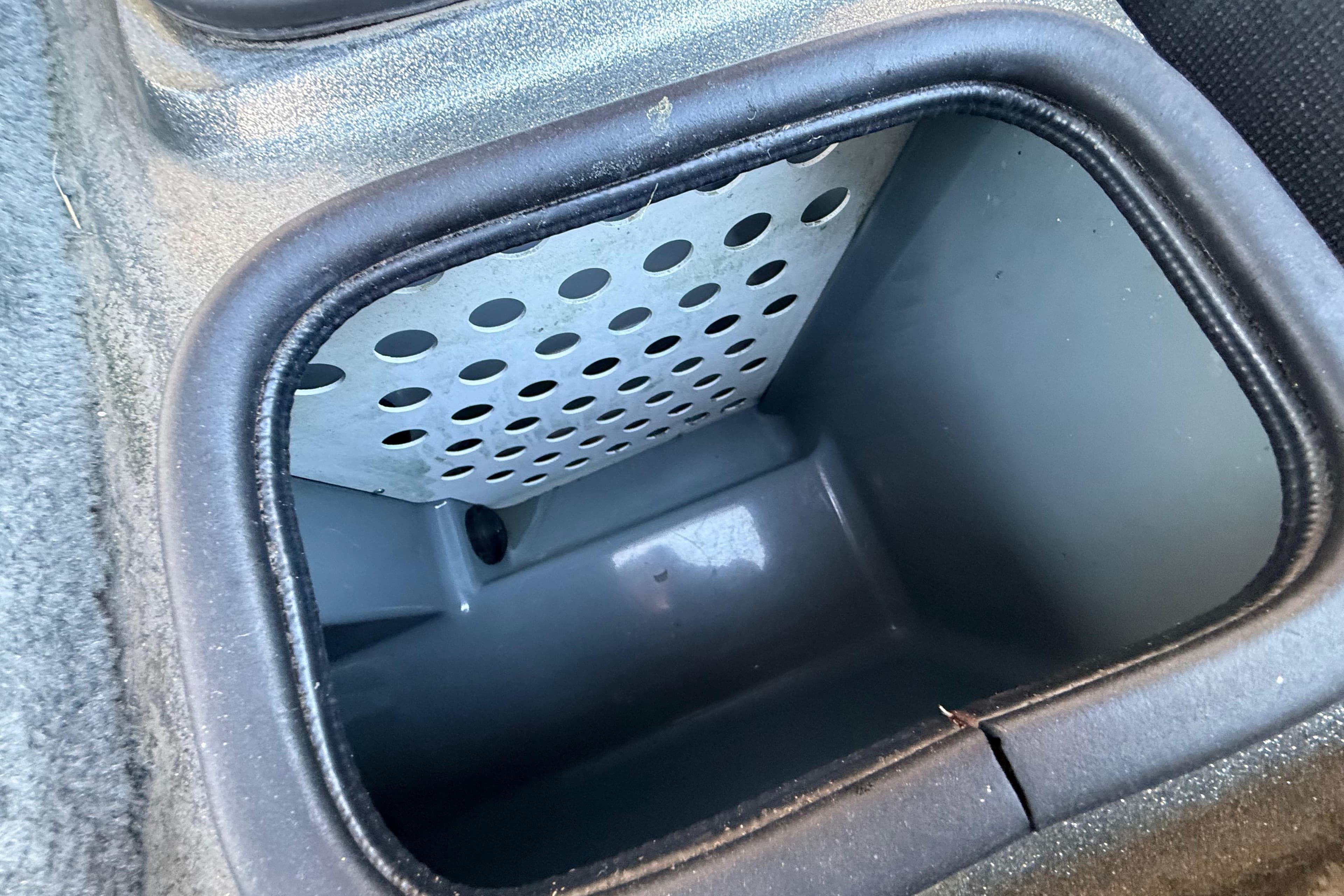 2005 Bass Cat Puma boat compartment with perforated interior design.