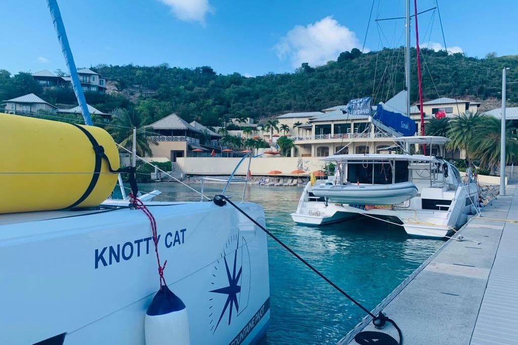 2022 Fountaine Pajot Tanna 47 catamaran docked in a scenic marina.