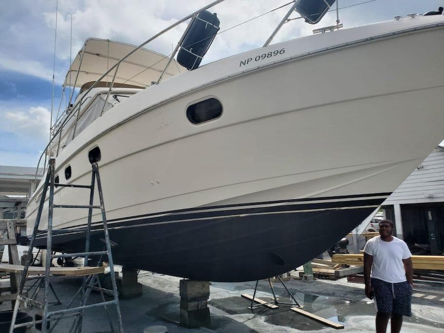 1998 Viking Sports Cruiser on dry dock with a ladder and a person nearby.