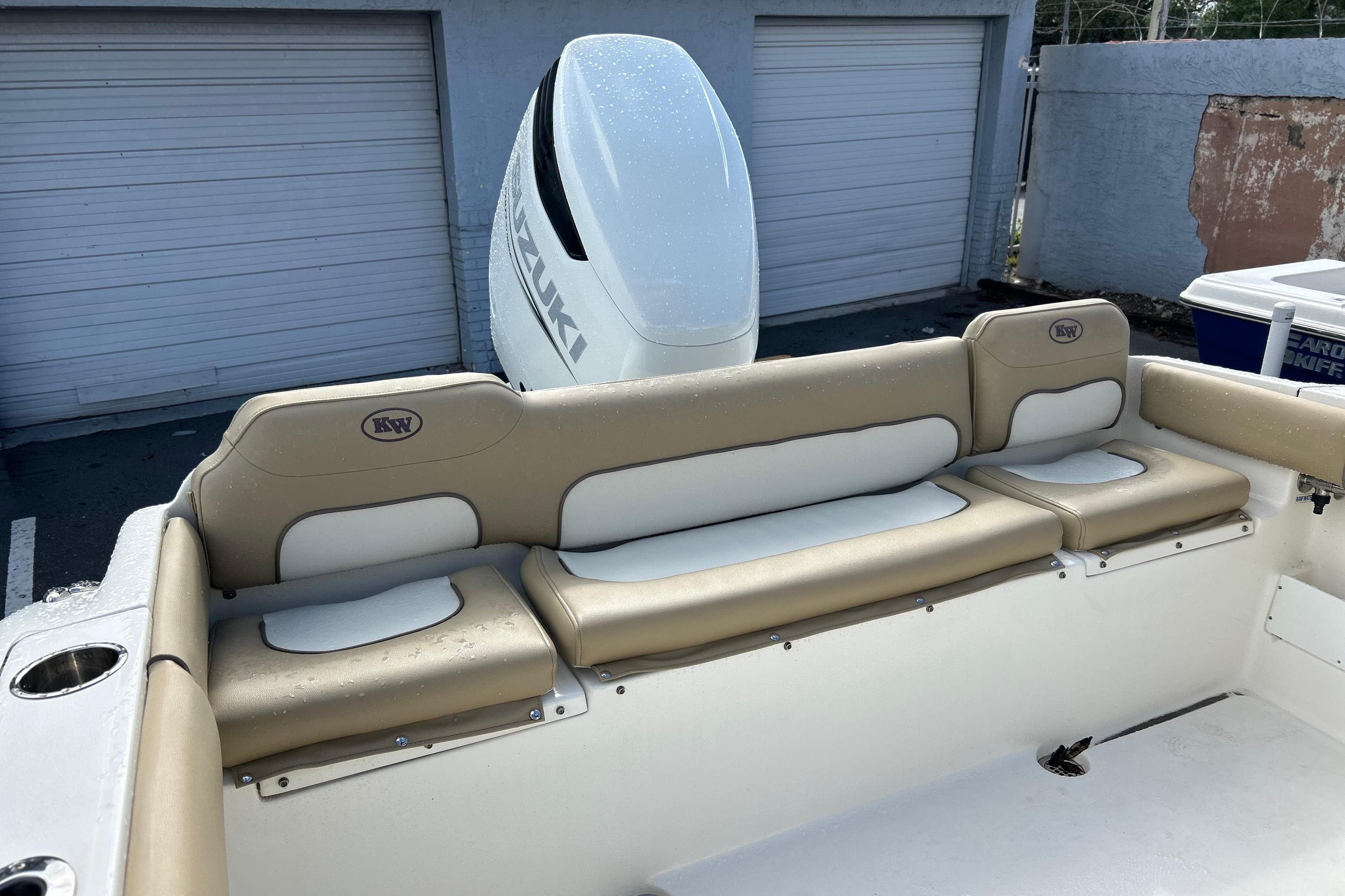 2019 Key West 239 FS boat interior with beige seating and Suzuki outboard motor.